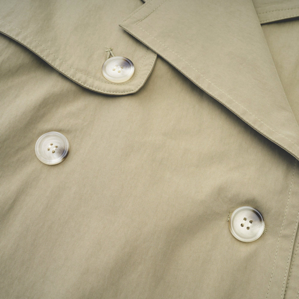 Abrigo trench con cinturón de la marca Bridal, de corte clásico y color neutro, mostrado en la imagen.