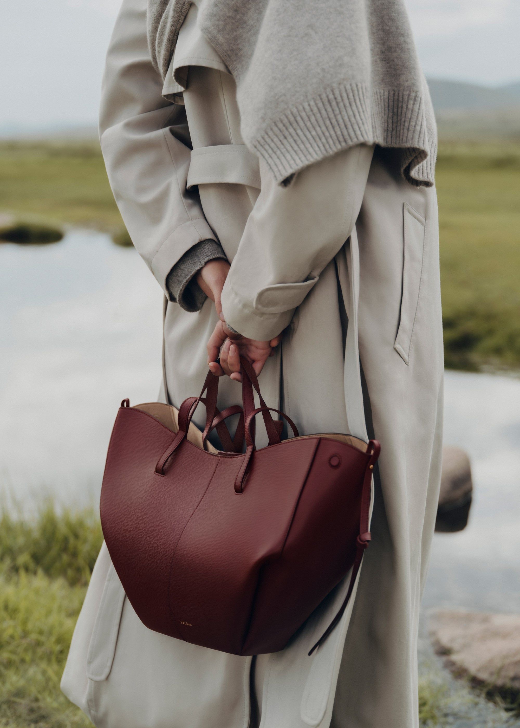 Bolso de mano Polène Cyme en piel granulada de cereza negra, con diseño elegante y detalles en textura.