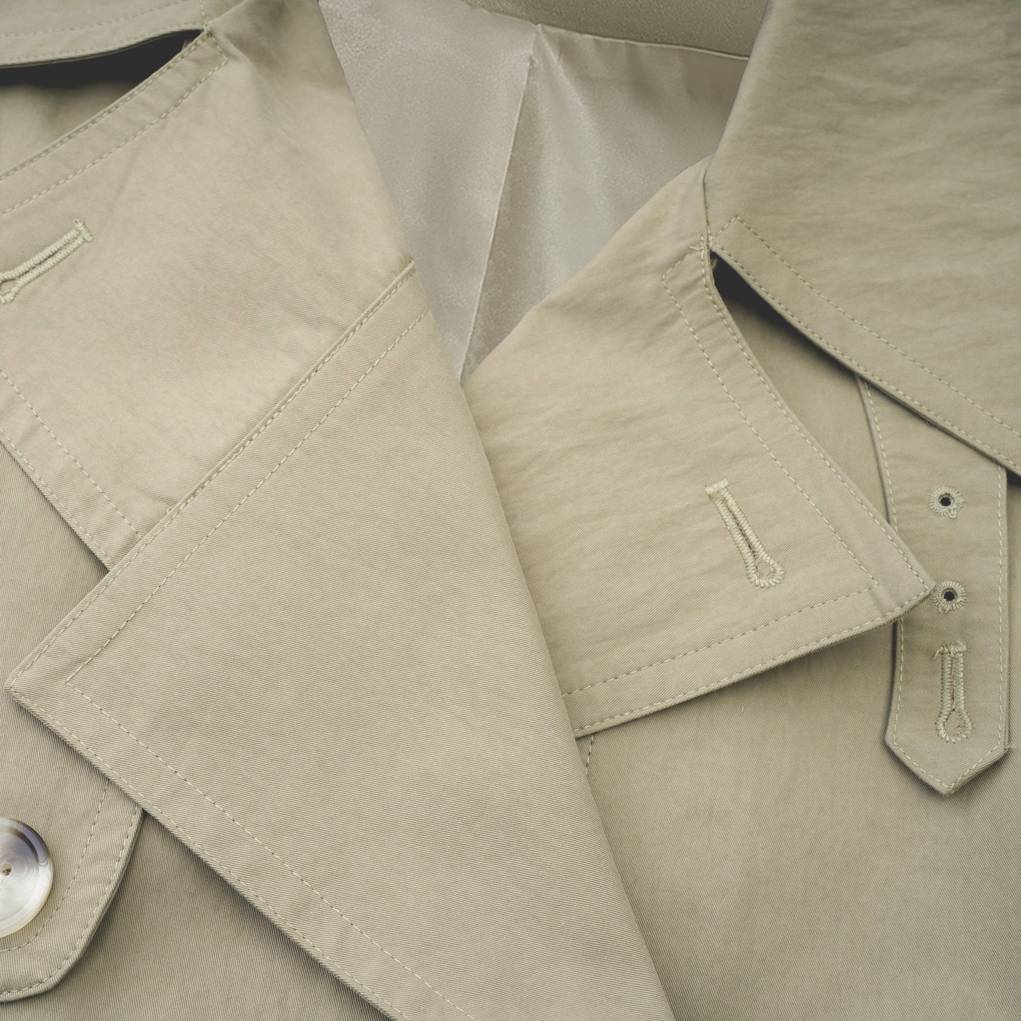 Abrigo trench con cinturón de la marca Bridal, color beige, con solapas y bolsillos frontales.