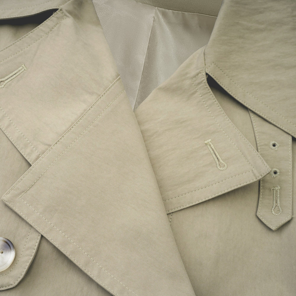Abrigo trench con cinturón de la marca MRNewyork, color beige, vista frontal, diseño clásico y elegante para mujer.