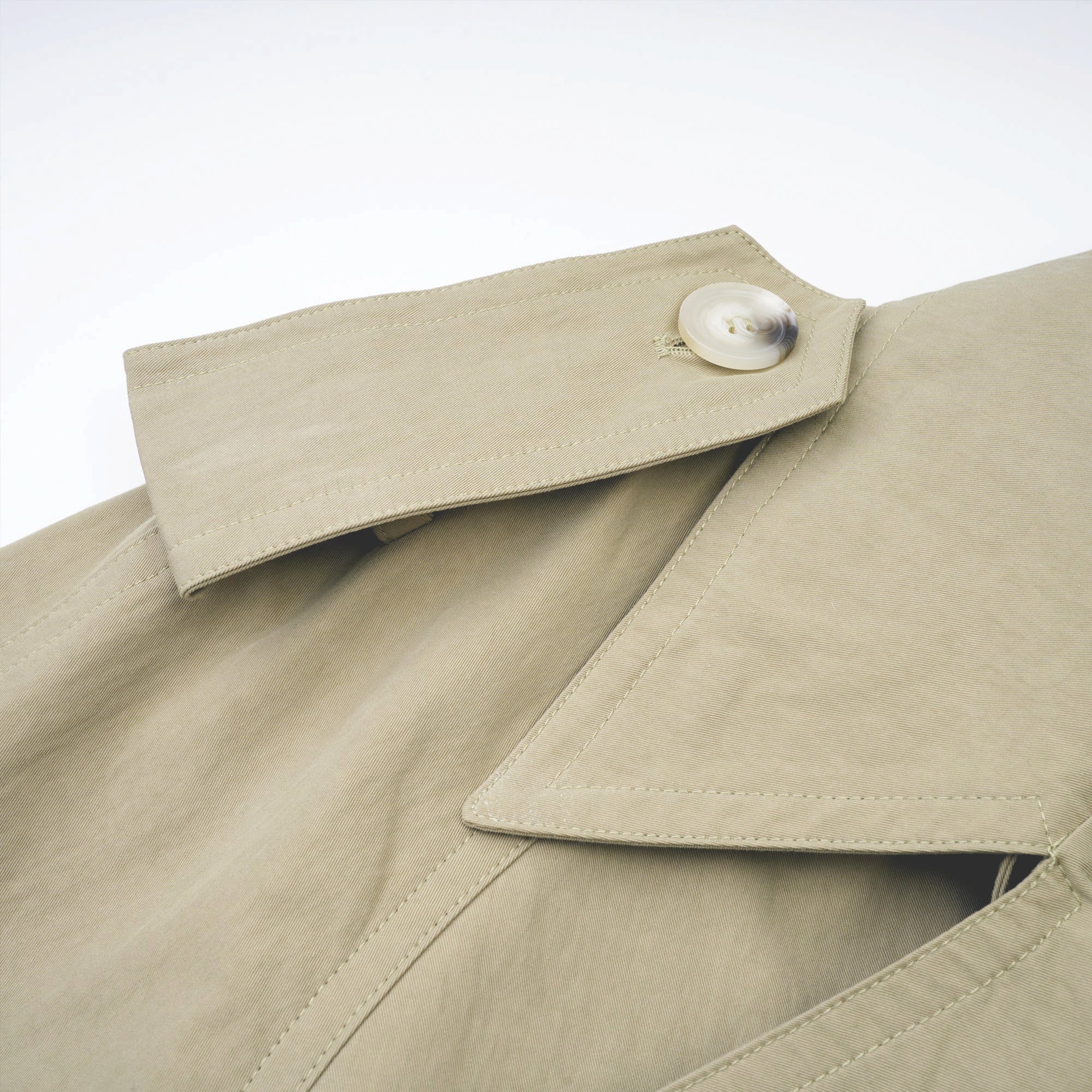 Abrigo trench con cinturón de la marca Bridal, color beige, con diseño clásico y detalles en la cintura.