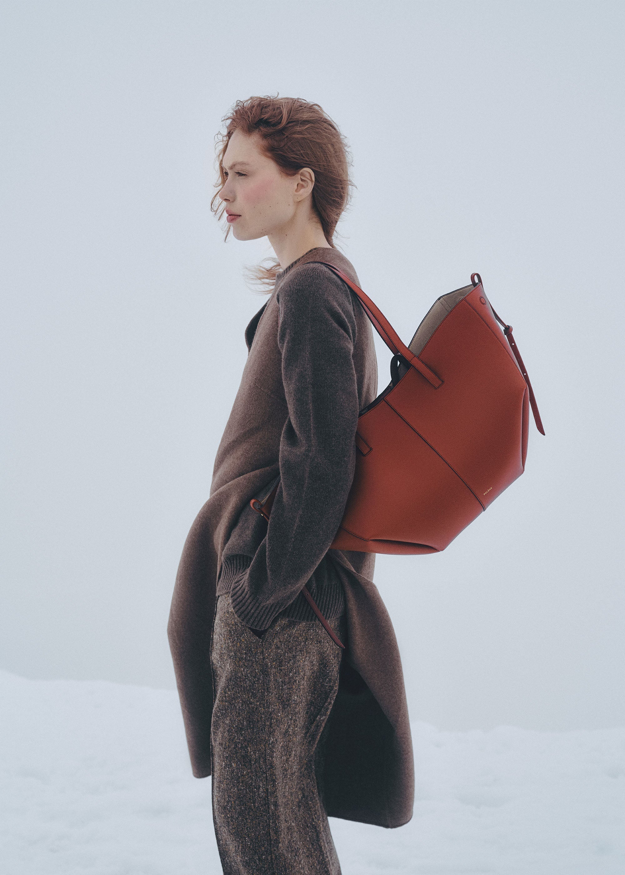 Mochila de mano Polène Cyme en arcilla roja con piel granulada y detalles en cuero natural.