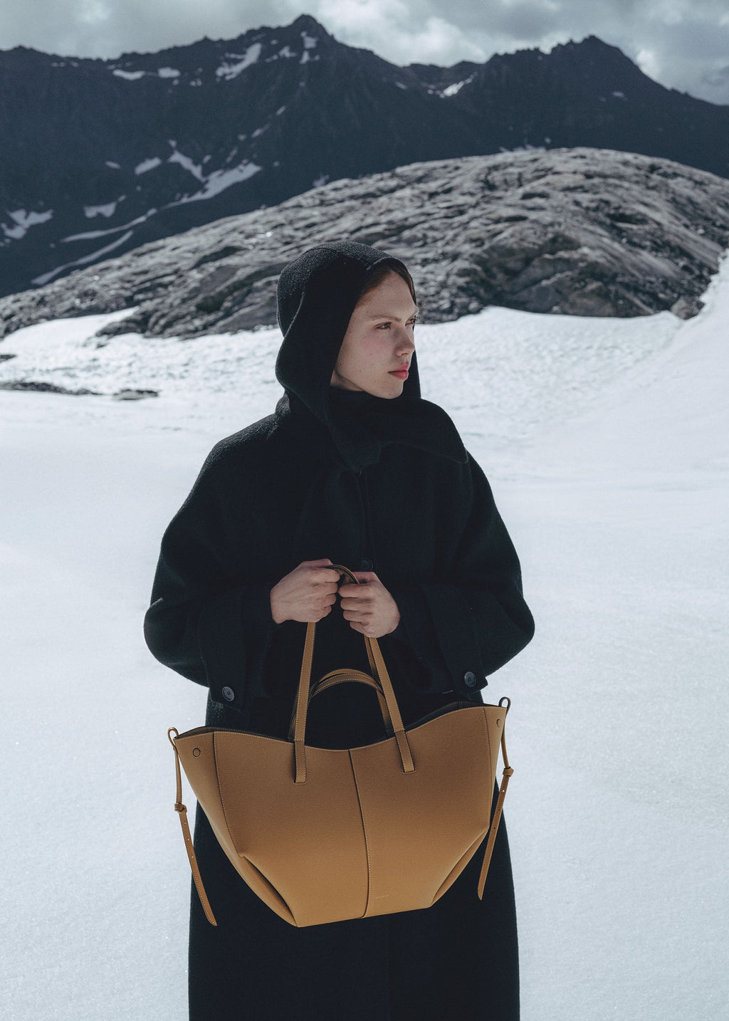 Bolso de mano Polène Cyme en piel ocre granulada, con diseño elegante y textura suave visible en la imagen.