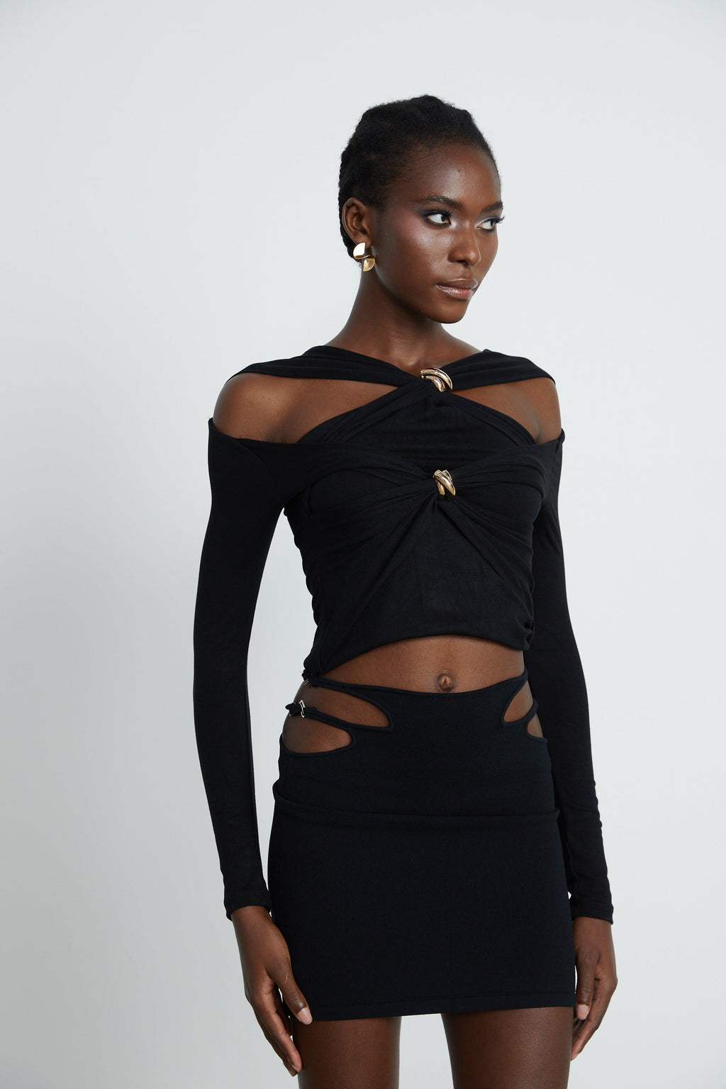 Blusa de manga larga Clarabelle con efecto fruncido y recortes en color negro, estilo moderno y casual.