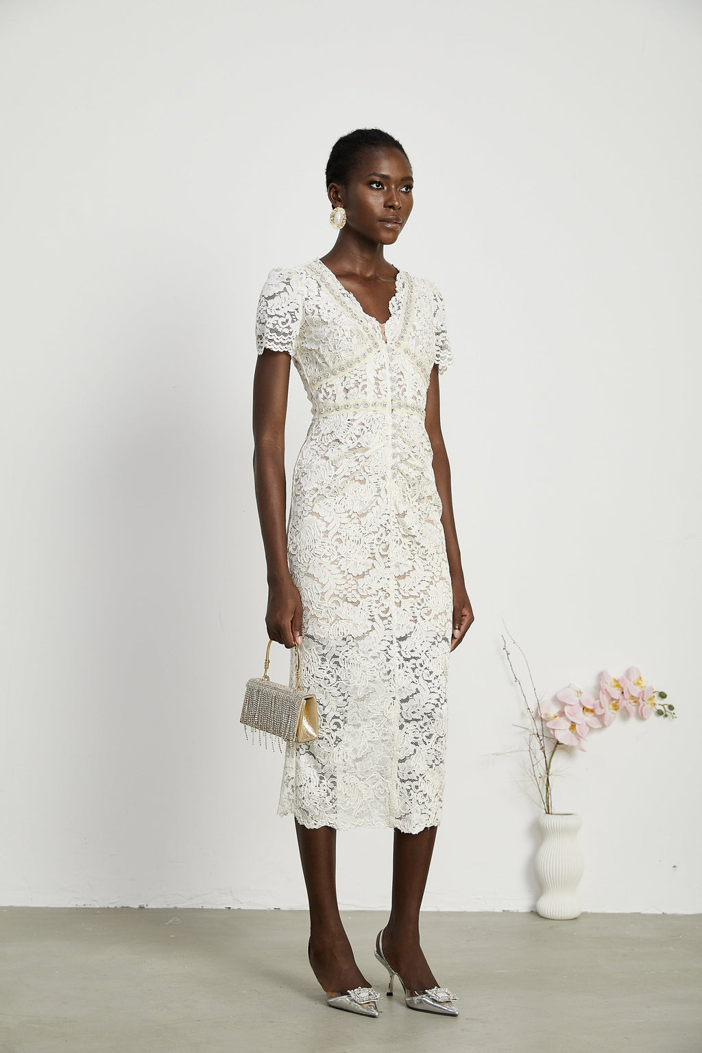 Vestido midi de encaje con detalles decorativos de Kalena, elegante y sofisticado, en color claro y tejido delicado.