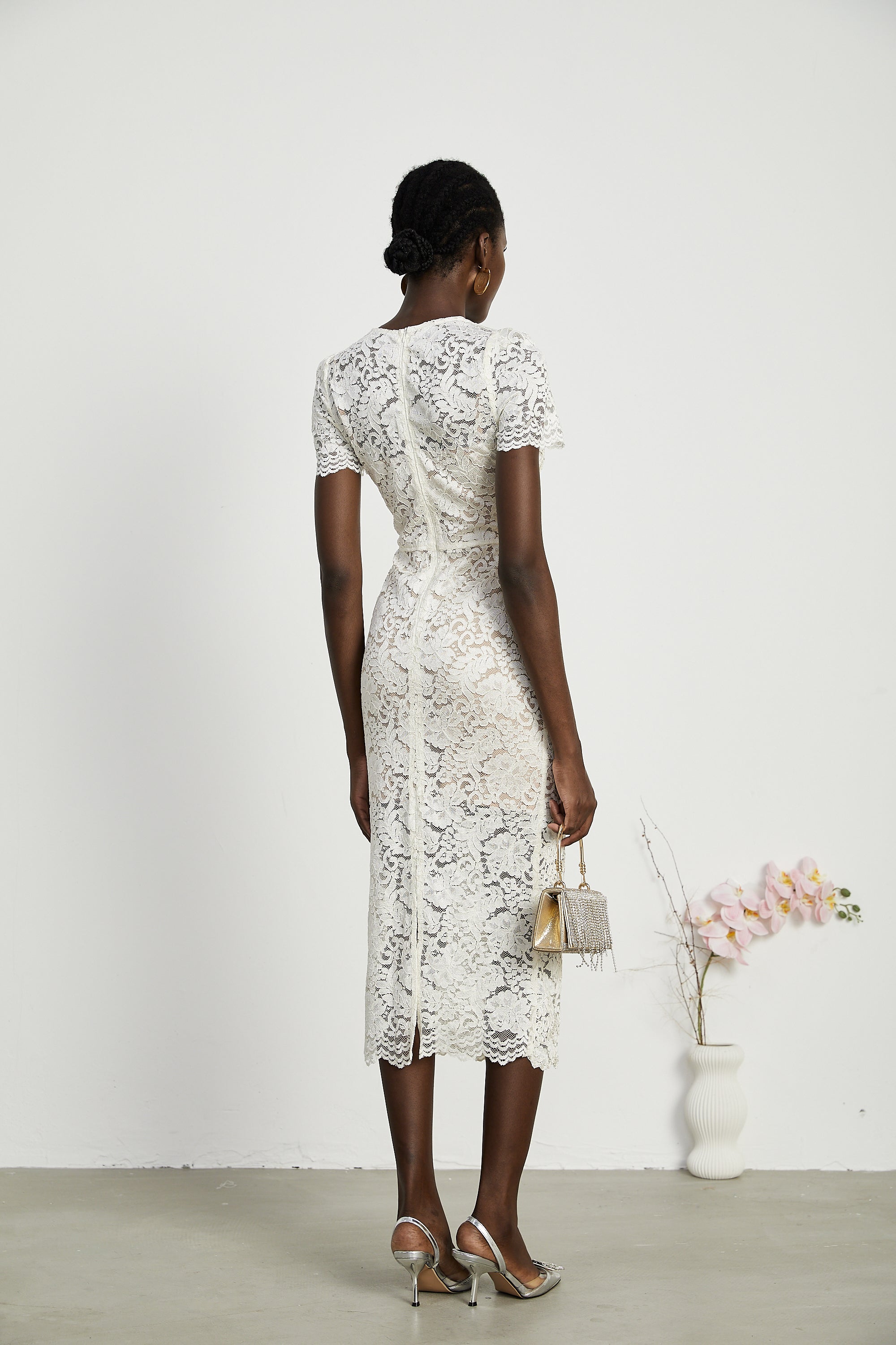 Vestido midi de encaje con bordados Kalena, elegante y femenino, en color claro con detalles decorativos en la parte superior.