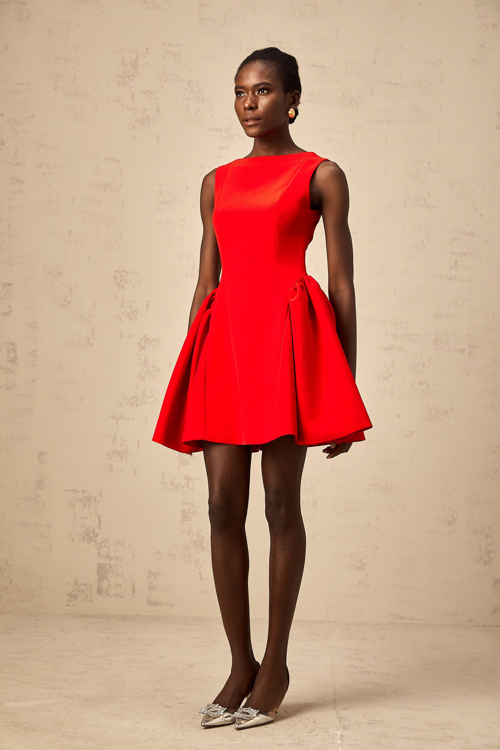 Vestido mini sin mangas rojo Yulia de corte acampanado, estilo elegante y femenino, en la imagen sobre fondo neutro.