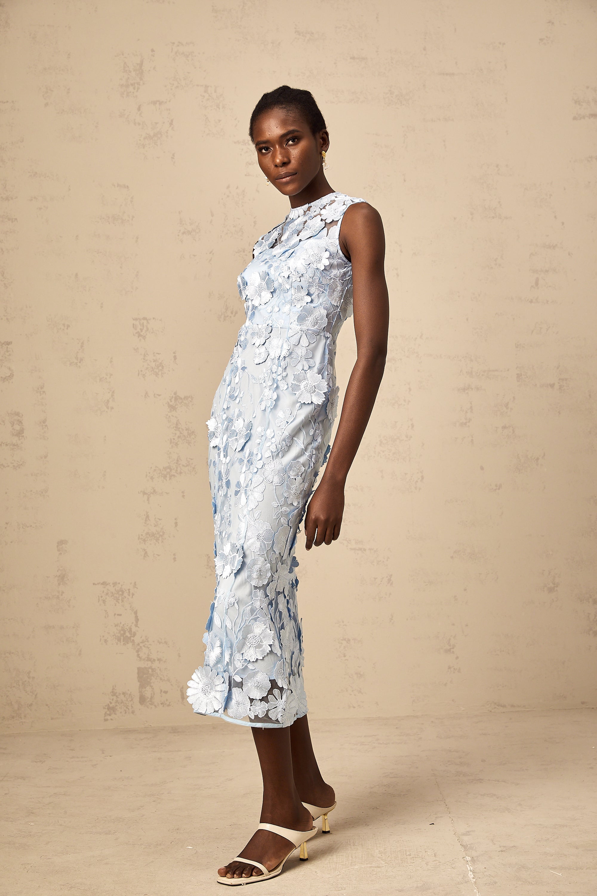 Vestido midi azul con aplicaciones florales de Herta, diseño elegante y femenino, con detalles en la tela y corte ajustado.