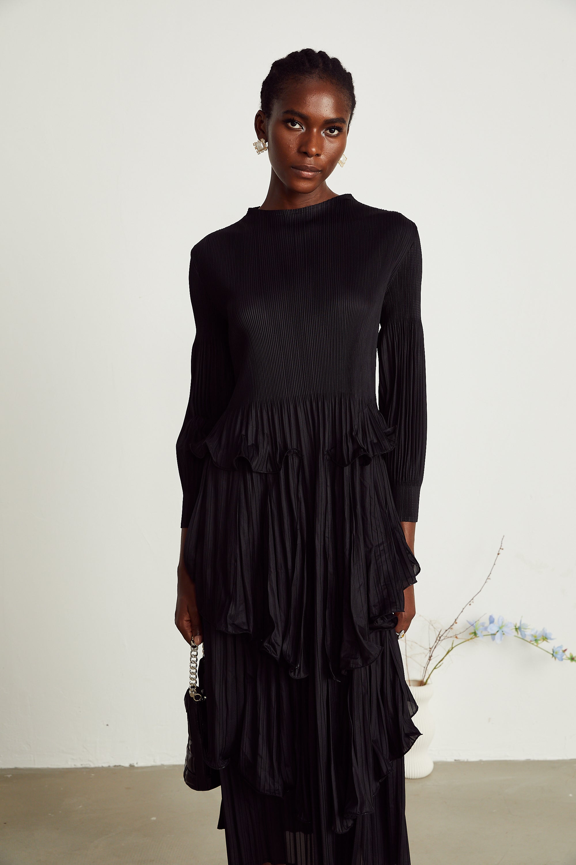 Vestido midi negro con pliegues en capas y falda en tiered, de la marca MRMelbourne, mostrando el diseño elegante y fluido.