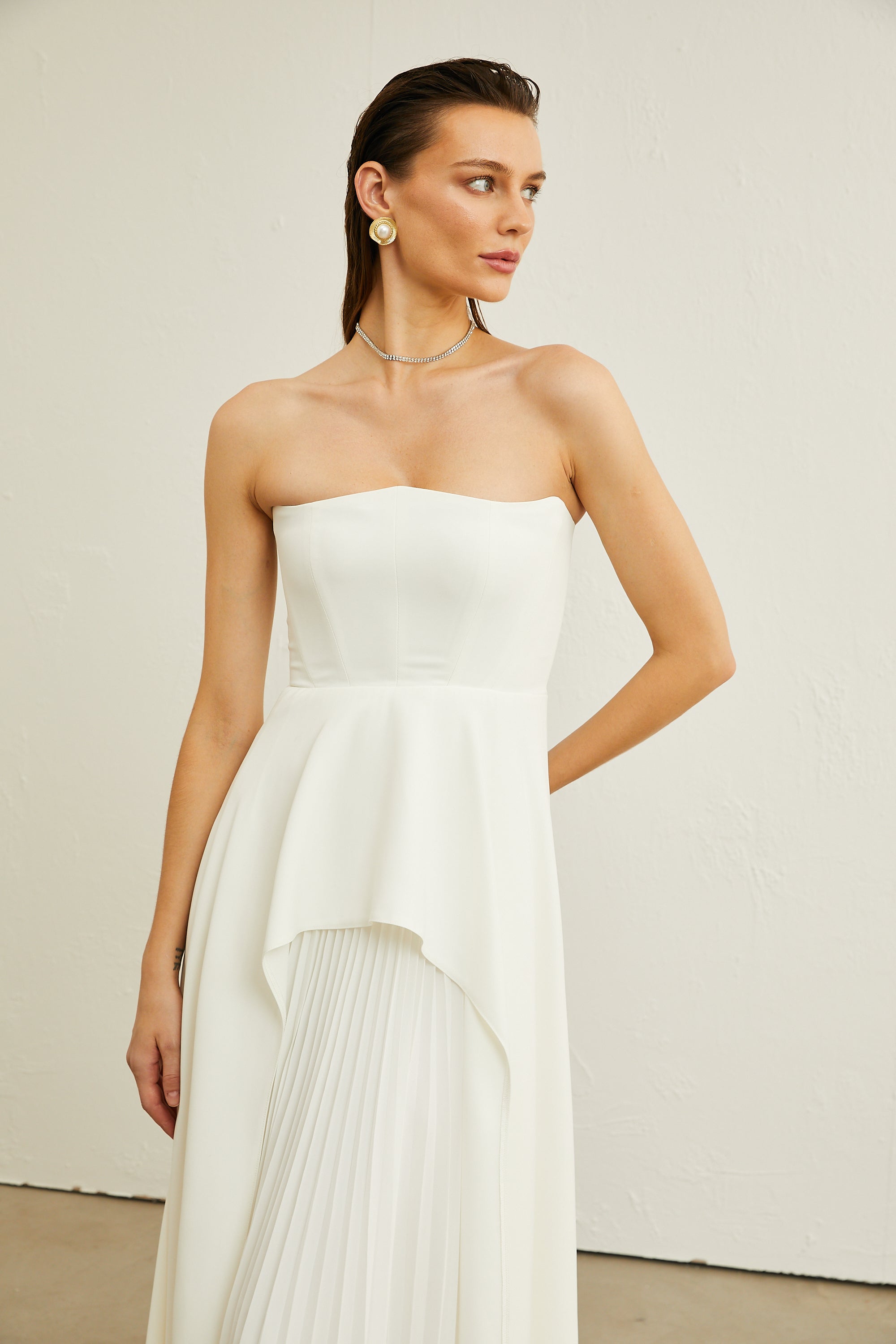 Vestido maxi blanco Vanessa con plisados y escote en hombro, diseño elegante para ocasiones especiales.