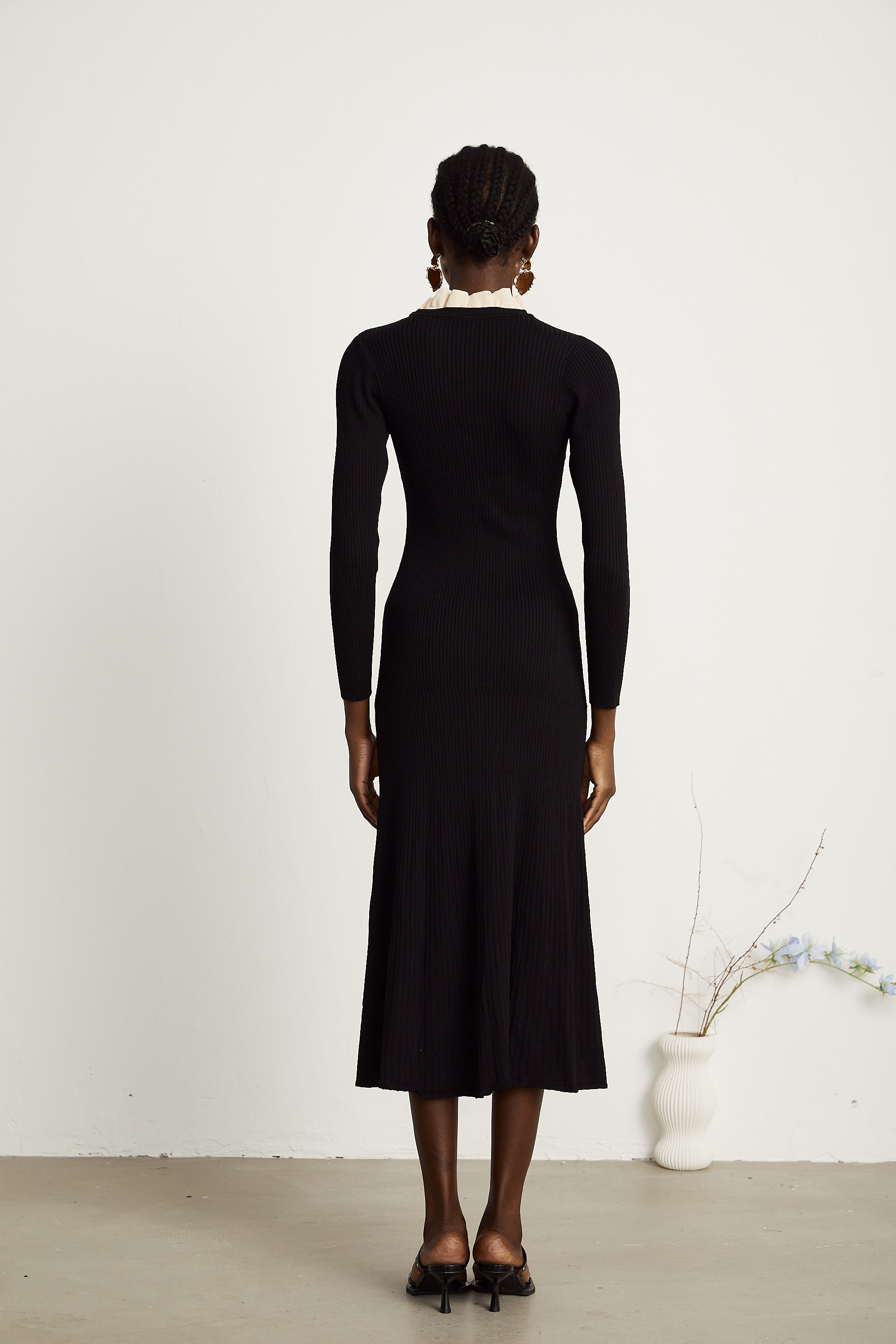 Vestido midi negro con cuello con volantes y tejido de punto de la marca Final Sale, vista frontal del vestido en la imagen.