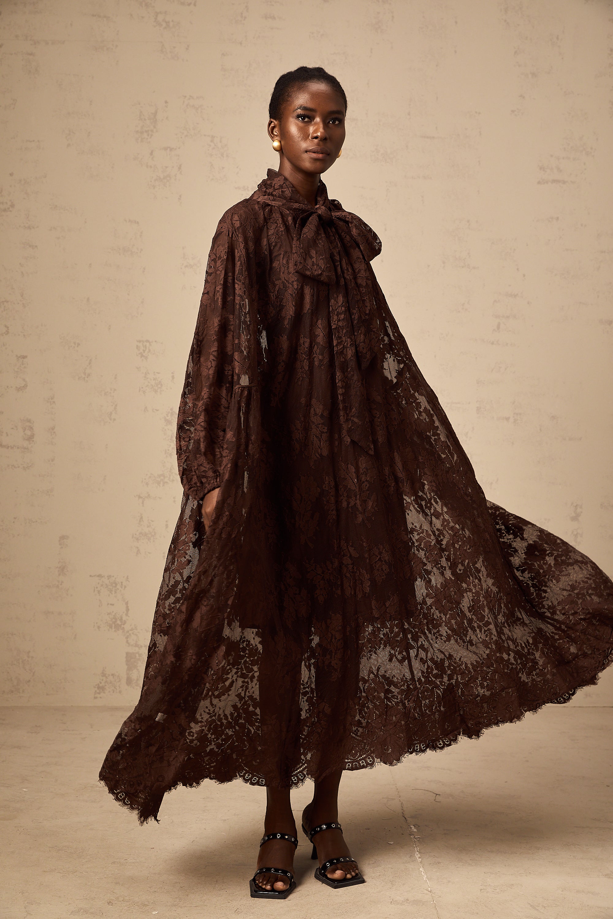 Vestido midi con vuelo en encaje chantilly marrón Sylvie, estilo femenino y elegante, con diseño ajustado en la parte superior.