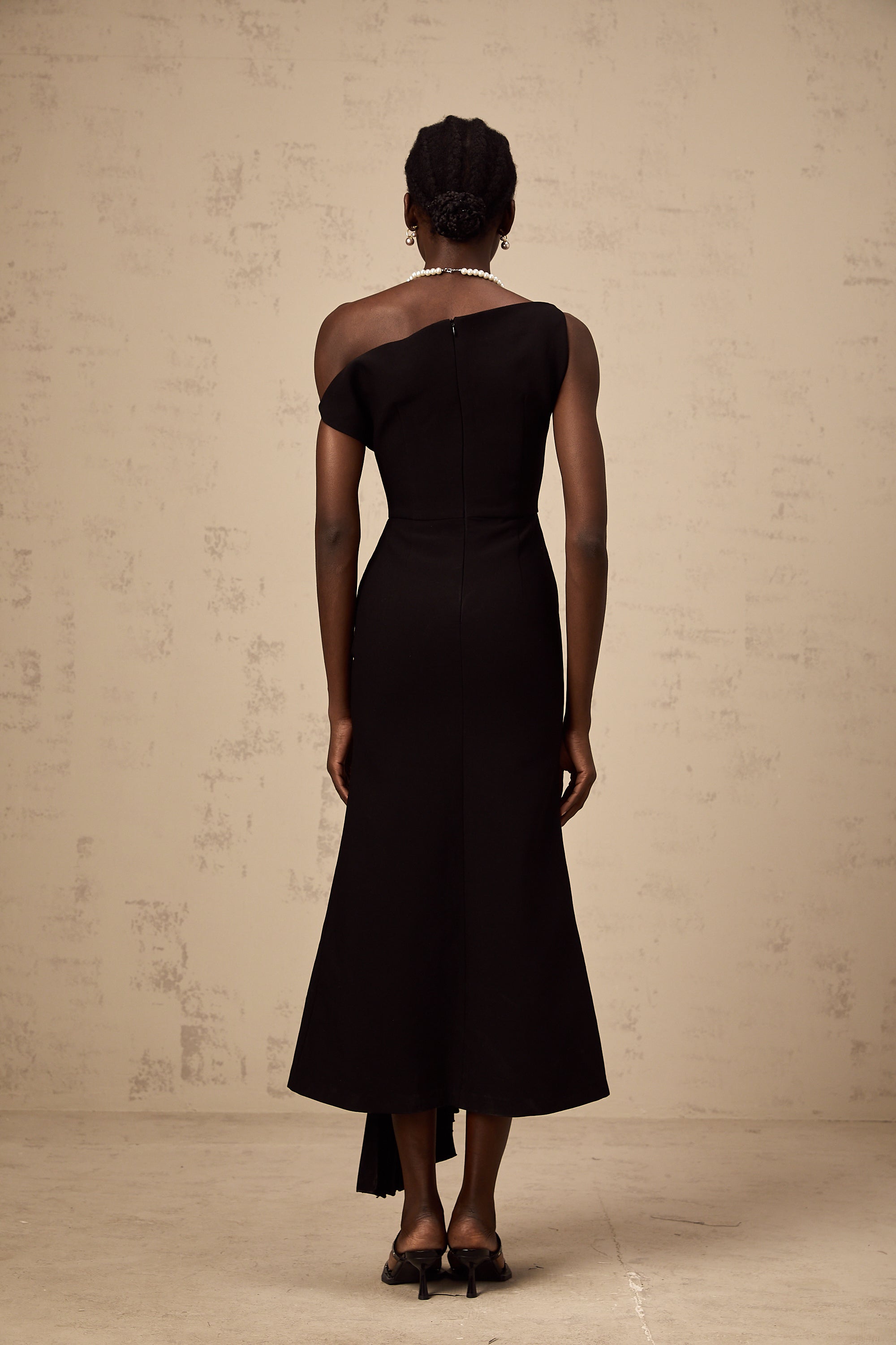 Vestido midi asimétrico negro Laurine de Final Sale, con drapeado elegante y diseño moderno.