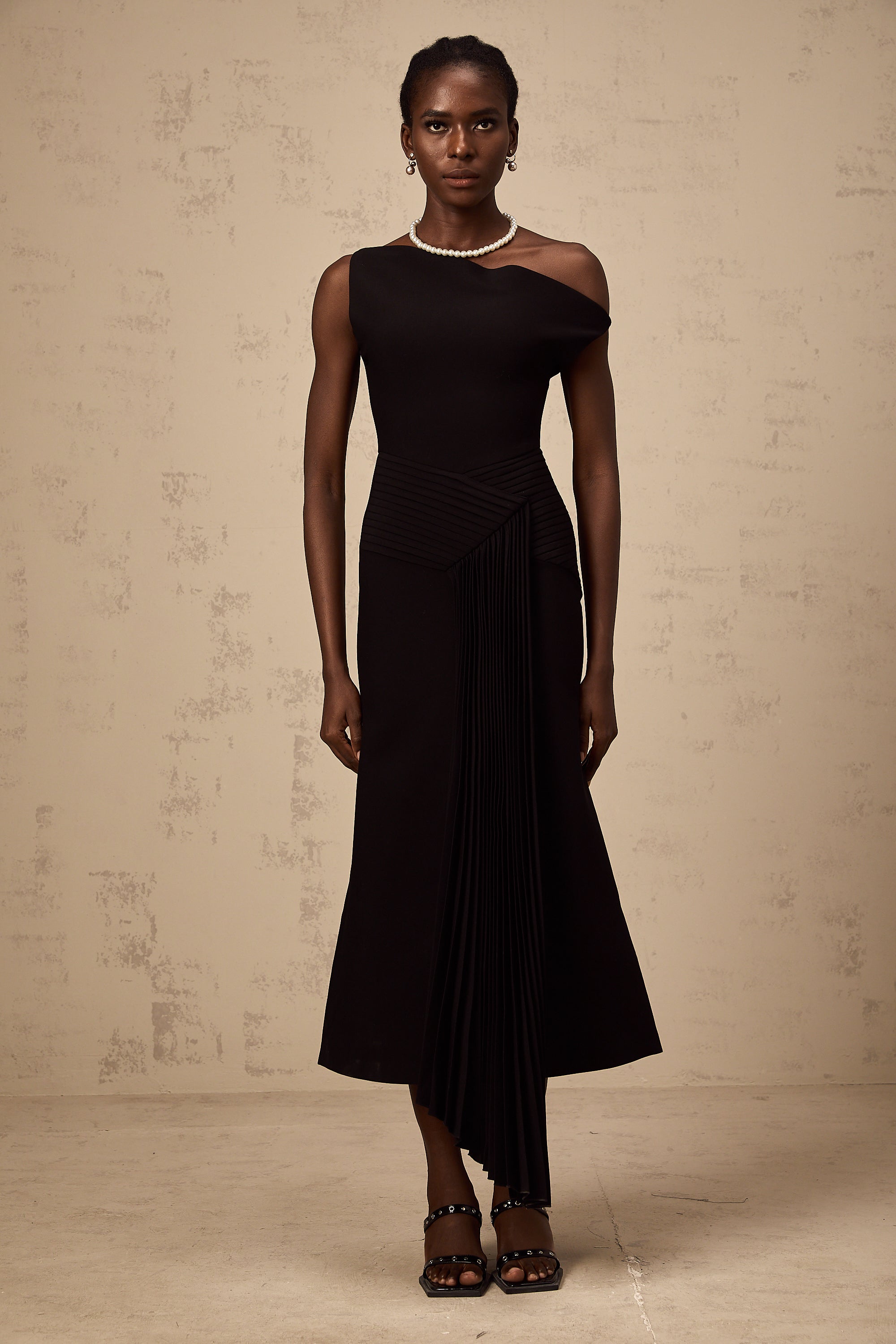 Vestido midi asimétrico negro Laurine de la marca Final Sale, con drapeado elegante y estilo moderno.