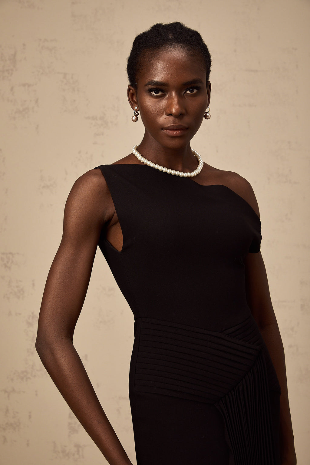 Vestido midi asimétrico negro Laurine de Final Sale, con drapeado elegante y corte moderno, visible en la imagen.
