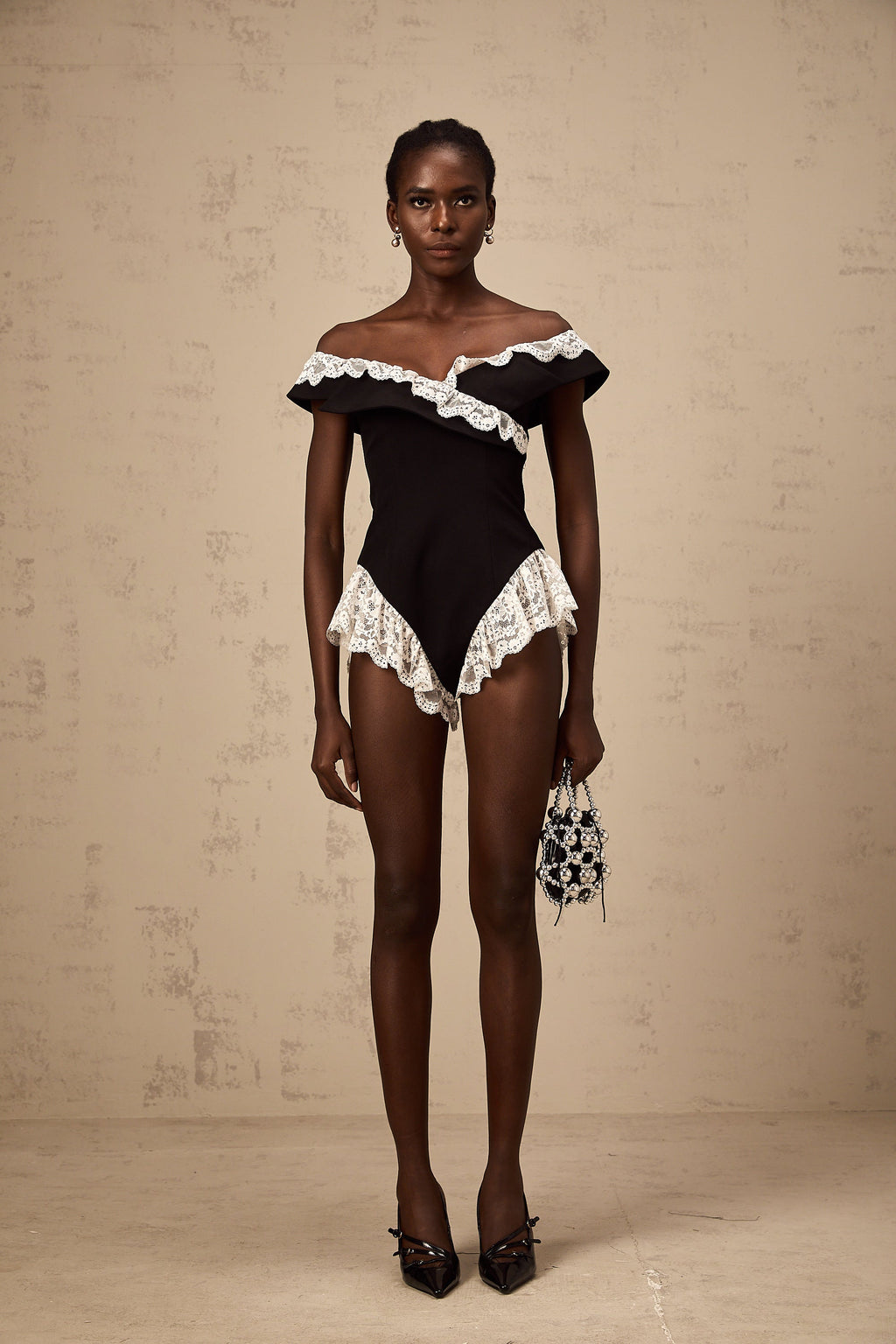 Bodysuit negro con encaje de la marca Final Sale, diseño ajustado y elegante, con detalles de encaje en el escote y las mangas.