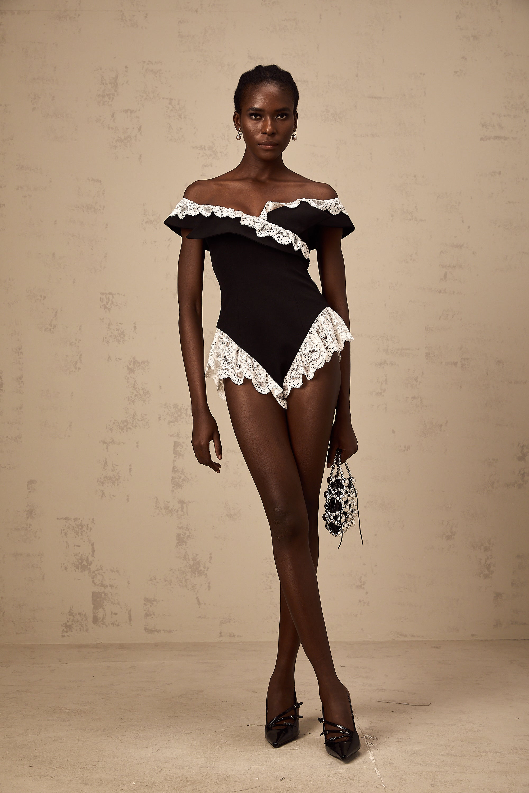 Body de encaje negro Karine de Final Sale, ajustado y elegante, con detalles de encaje en el cuello y las mangas.