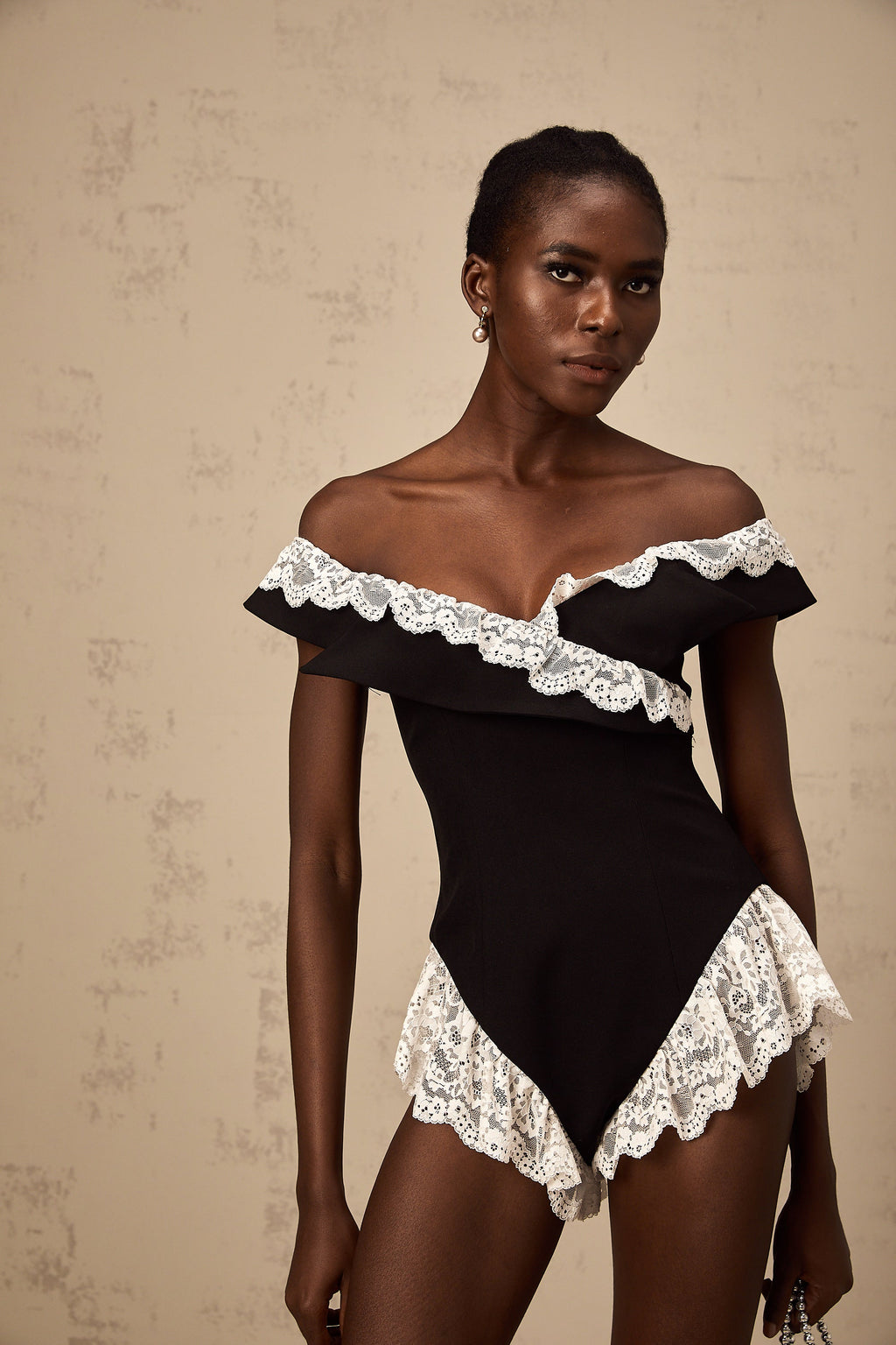 Bodysuit negro con encaje de Karine, ajustado y elegante, con detalles de encaje en los bordes y escote en V.