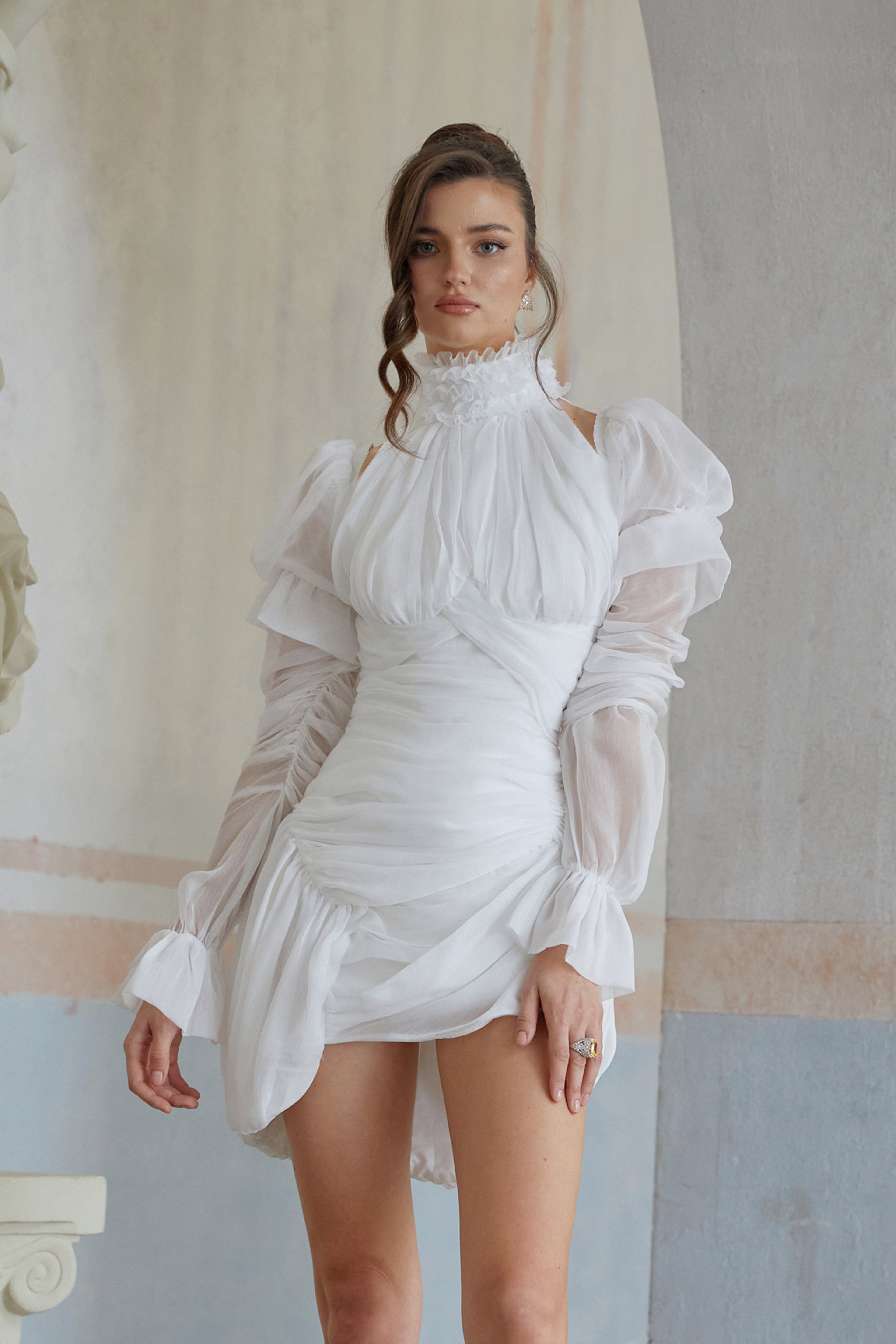Vestido mini asimétrico blanco Déotille con fruncido, ajustado y estilo moderno, en una modelo luciendo la prenda.