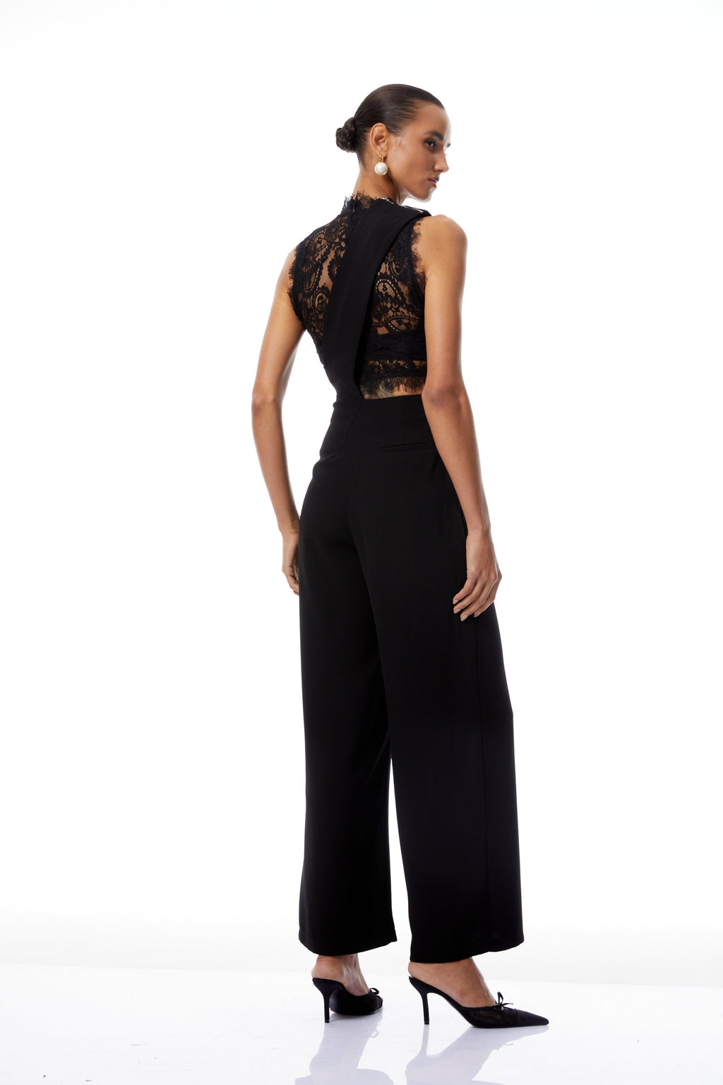 Mélisande conjunto de blusa de encaje negro y mono con tirantes asimétricos, estilo moderno y elegante.