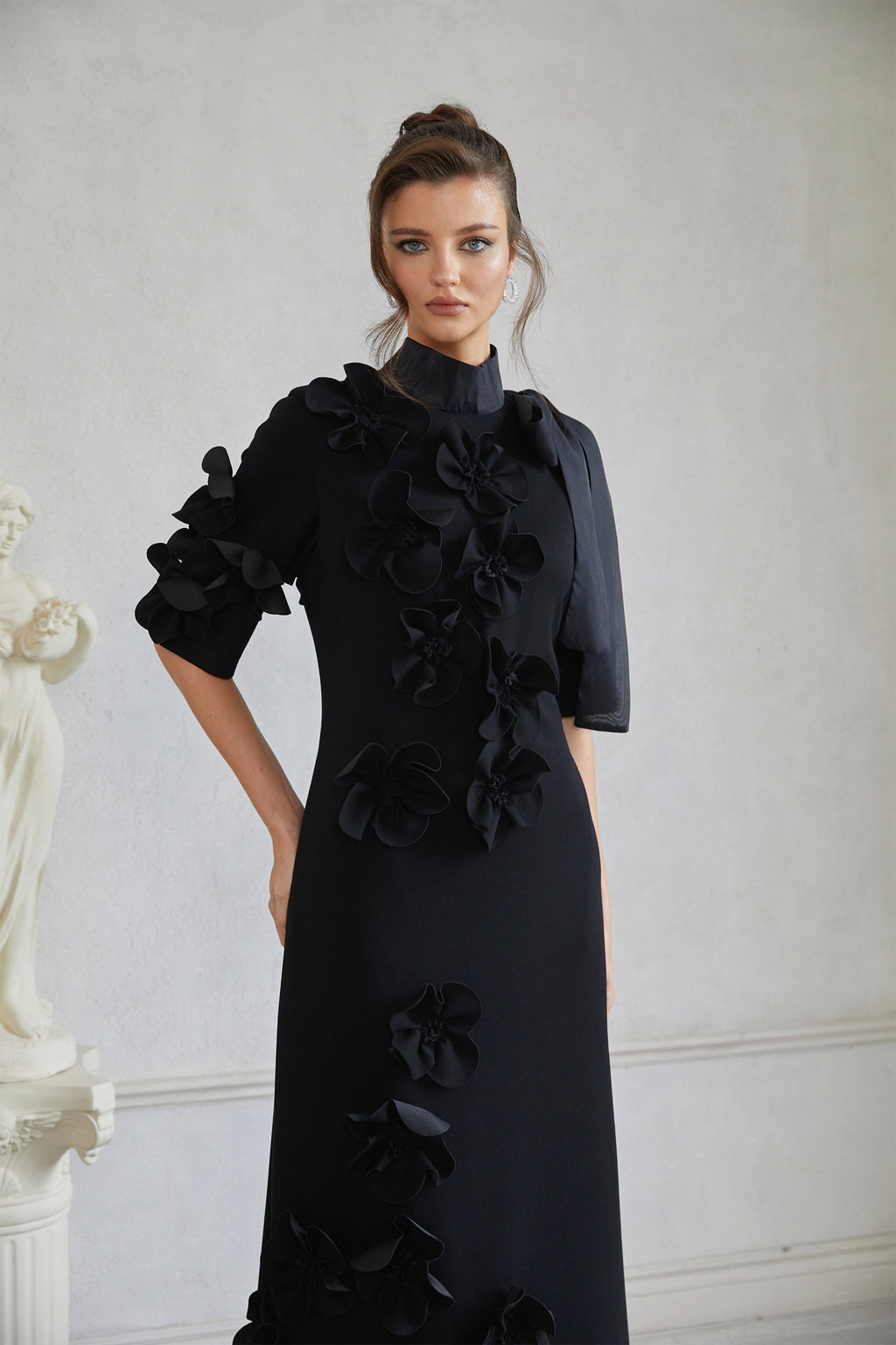 Vestido largo negro Isidora de Bridal con lazo en la espalda y aplicaciones florales, estilo maxi para ocasiones elegantes.