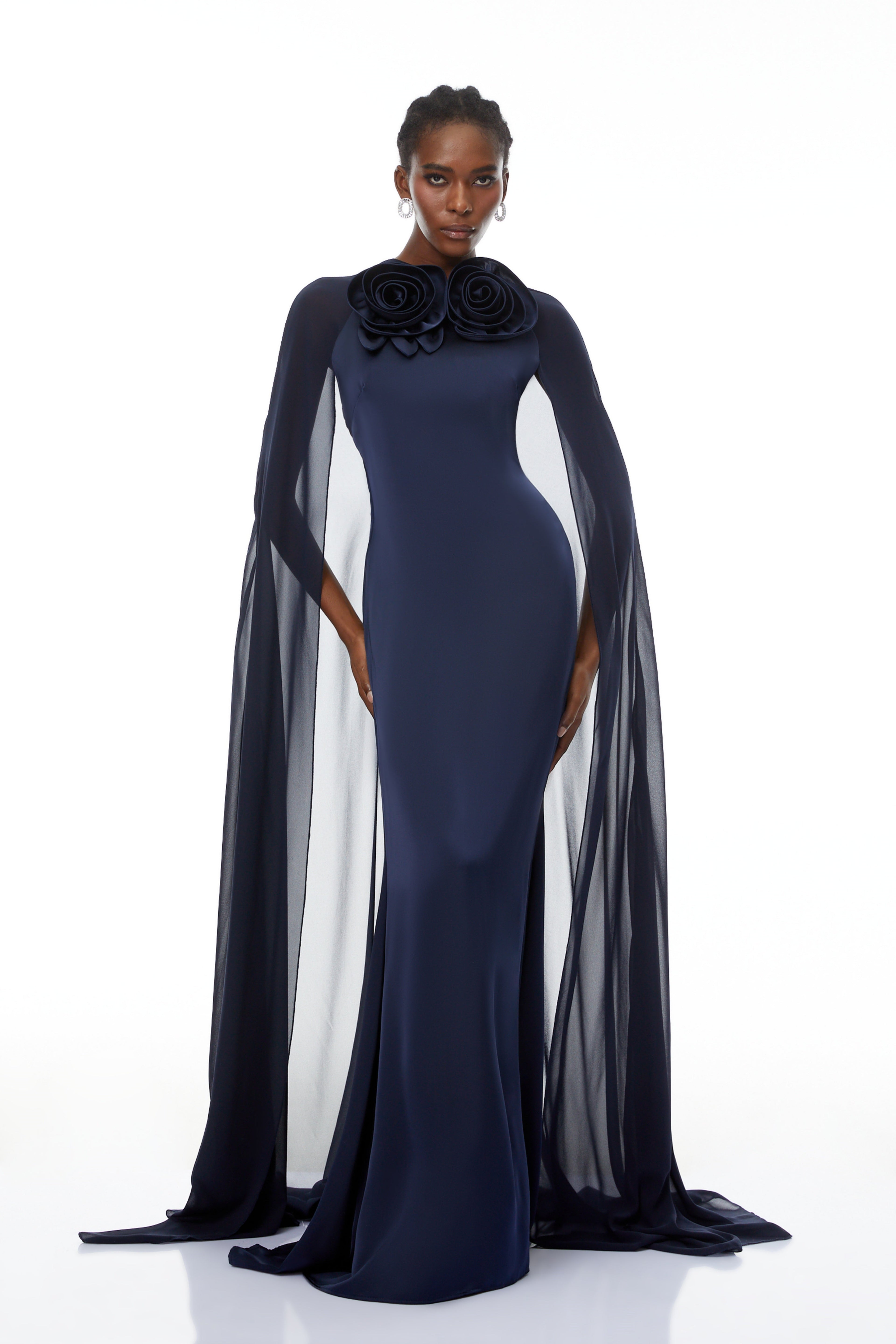 Mujer con vestido largo azul Riccardo Blue 3D Petal Cape Maxi Gown de MRMelbourne, con detalles de capa y diseño elegante.