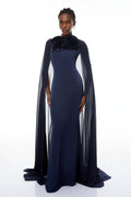 Mujer con vestido largo maxi Riccardo Blue 3D Petal Cape de MRMelbourne, diseño elegante con capucha y detalles en azul.