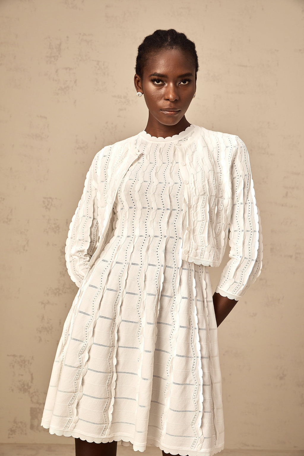 Cardigan de punto blanco Esmée con volantes, diseño de manga larga y detalles acampanados, para un estilo elegante y cómodo.
