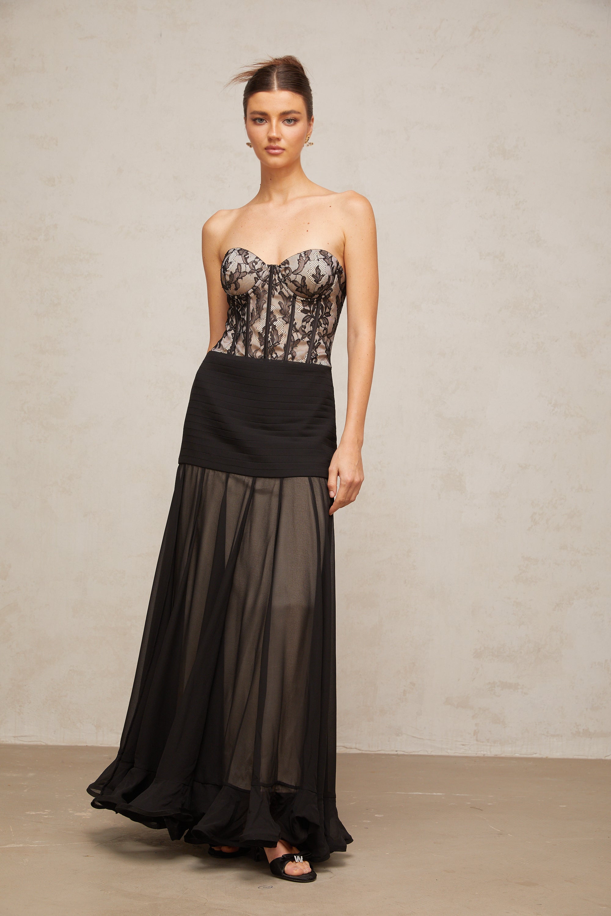Vestido maxi negro de encaje con volante de pétunia, diseño elegante y fluido, perfecto para ocasiones formales.