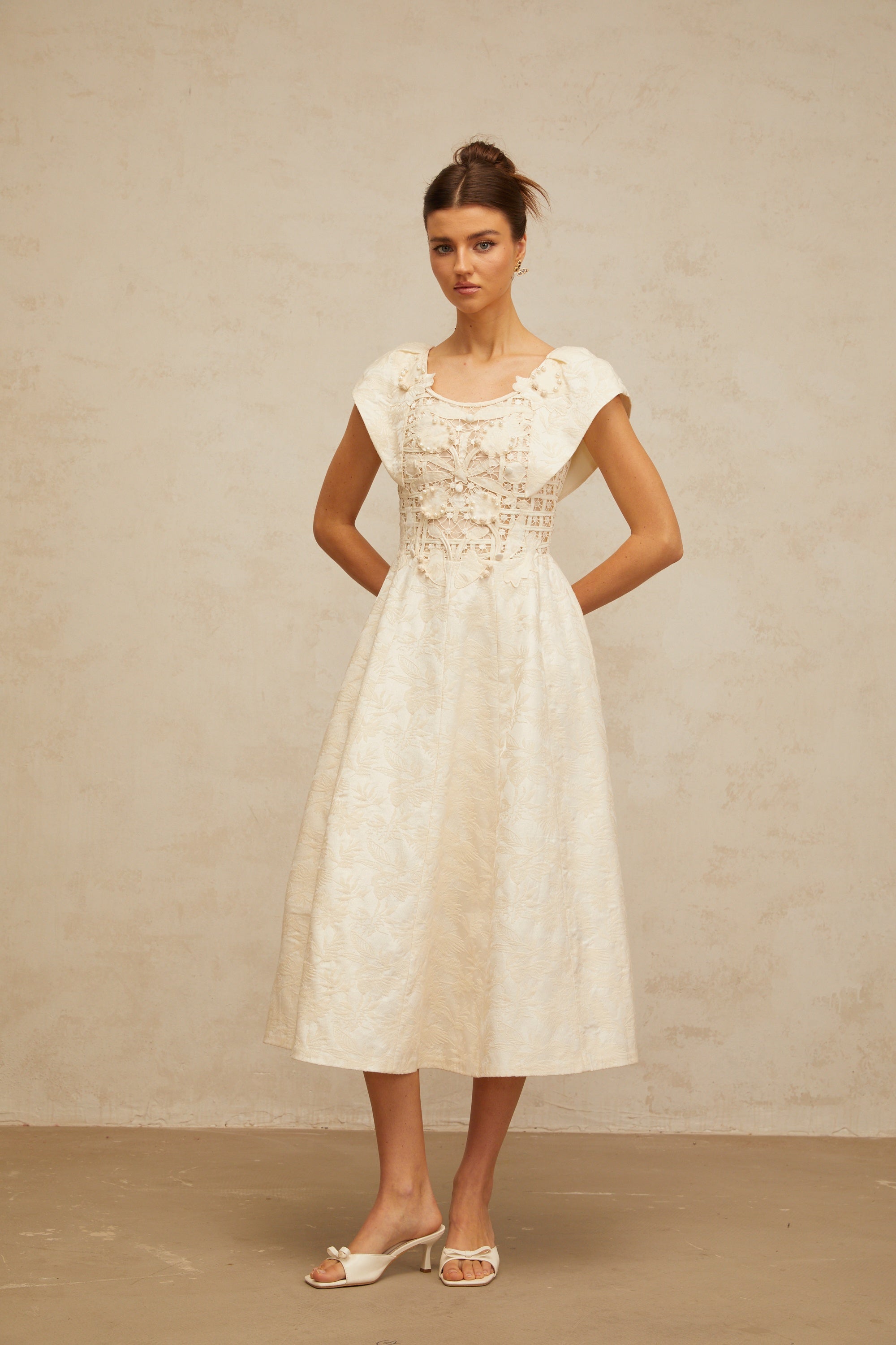 Vestido midi de Xenia con bordado floral en tonos neutros y detalles adornados, diseñado para una apariencia elegante y sofisticada.