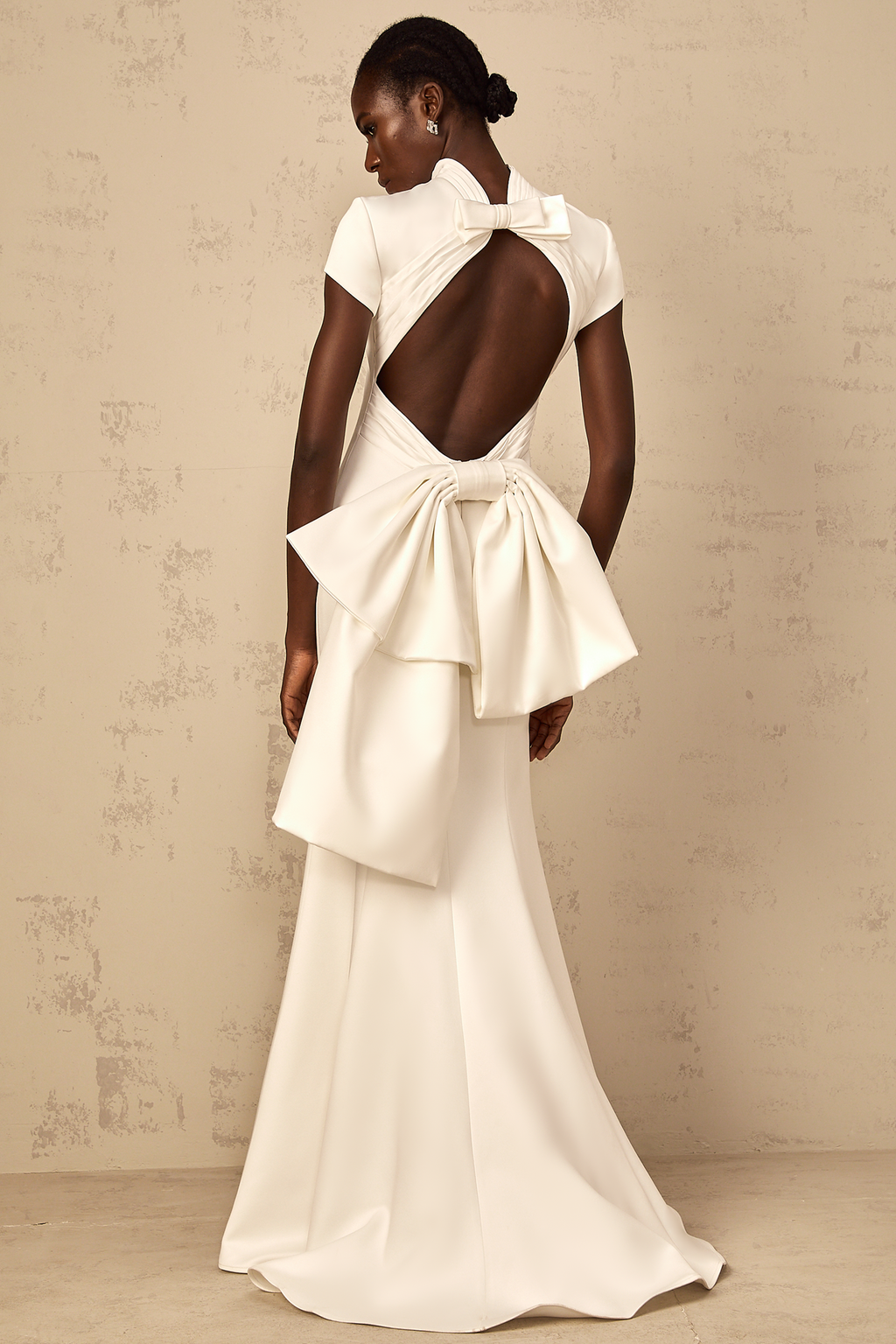Vestido maxi de sirena blanco Camille con lazo llamativo, estilo elegante y moderno para ocasiones especiales.