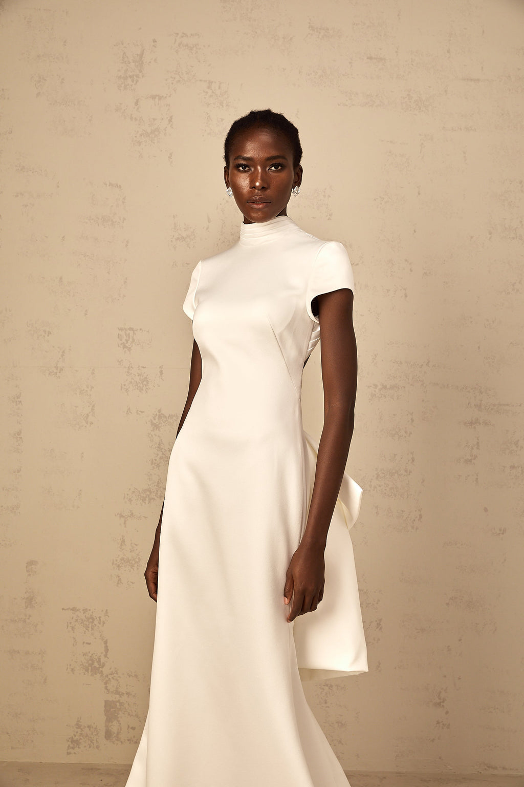 Vestido largo mermaid blanco Camille con lazo llamativo y estilo statement, ideal para ocasiones especiales.