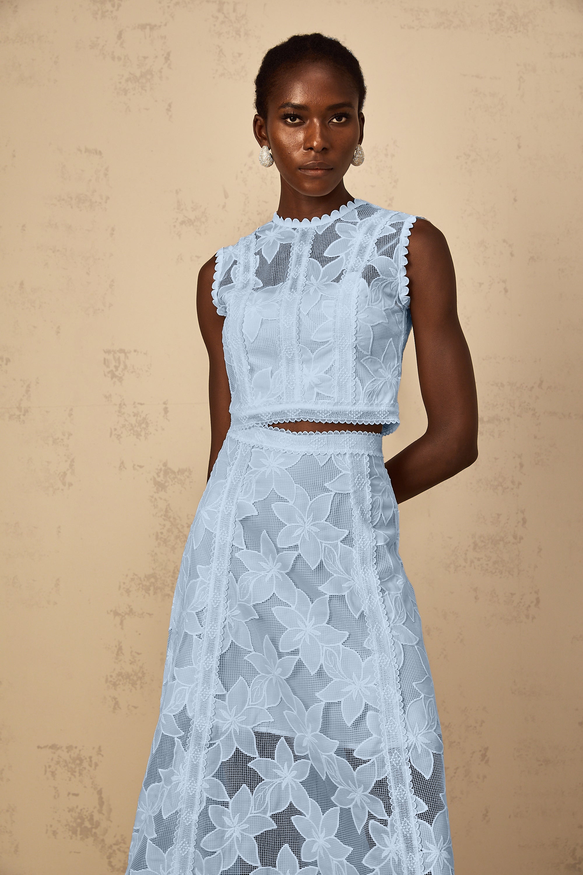 Conjunto de blusa y falda con bordado floral azul de MRMelbourne, estilo elegante y delicado, en un fondo neutro.