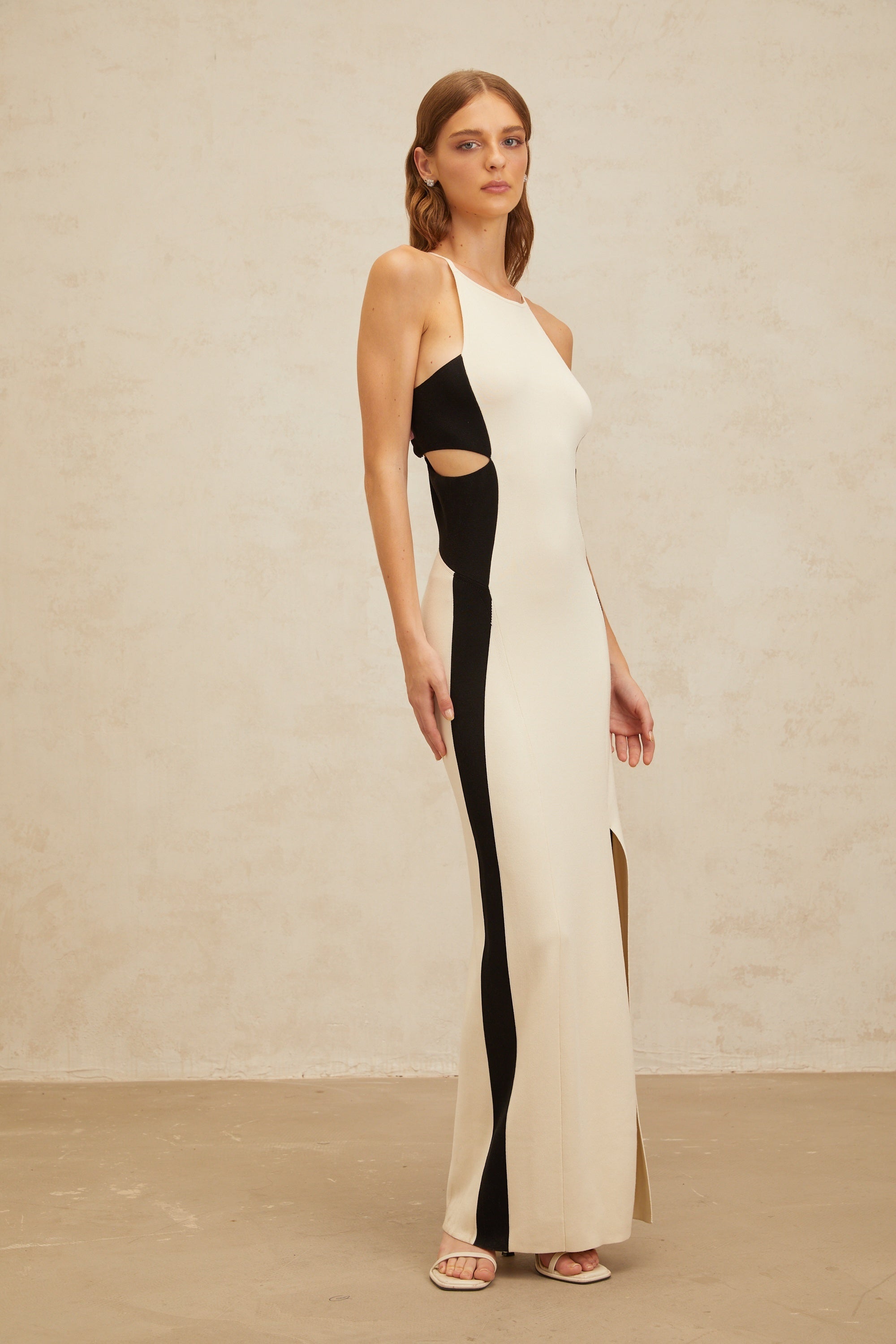 Vestido maxi de punto blanco Coralie con recortes, estilo elegante y moderno, ideal para ocasiones especiales.