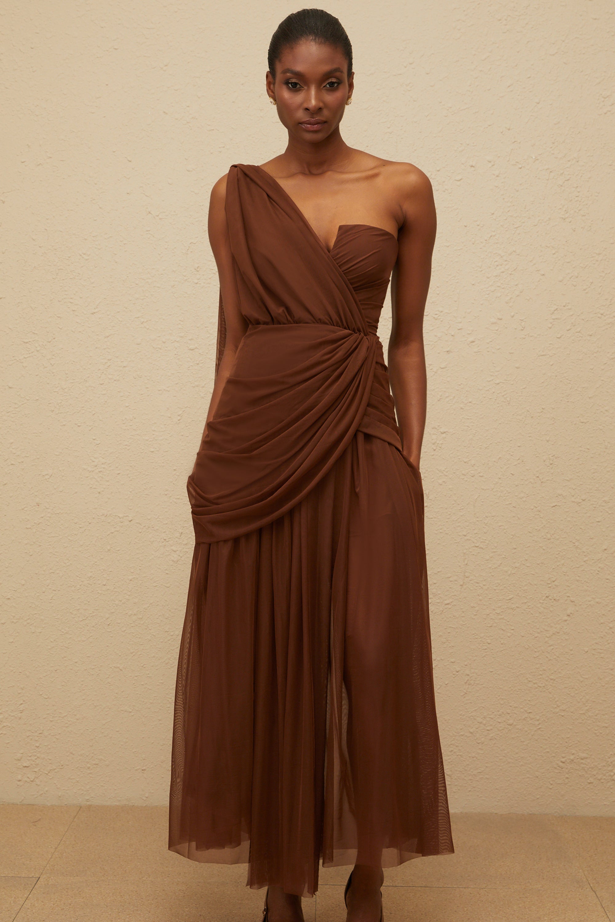 Vestido maxi de noche asimétrico en marrón Agathe, elegante y largo, con detalles sofisticados para eventos formales.
