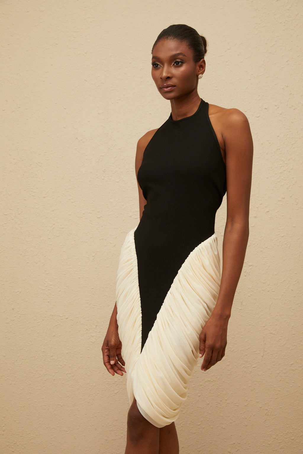Vestido midi ajustado negro de jade con escote halter y detalles fruncidos, de la marca MRTokyo, sobre fondo neutro.