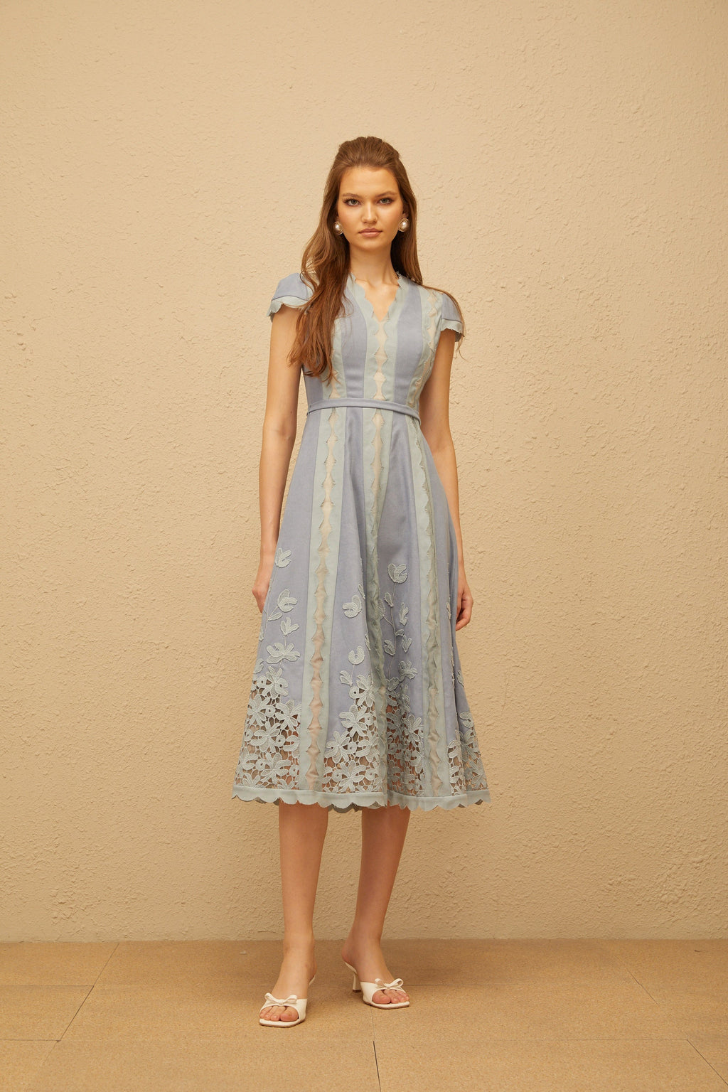 Vestido midi azul Amália con bordado floral y ribetes en ondas, de MRNewyork, mostrando su diseño elegante y detalles decorativos.