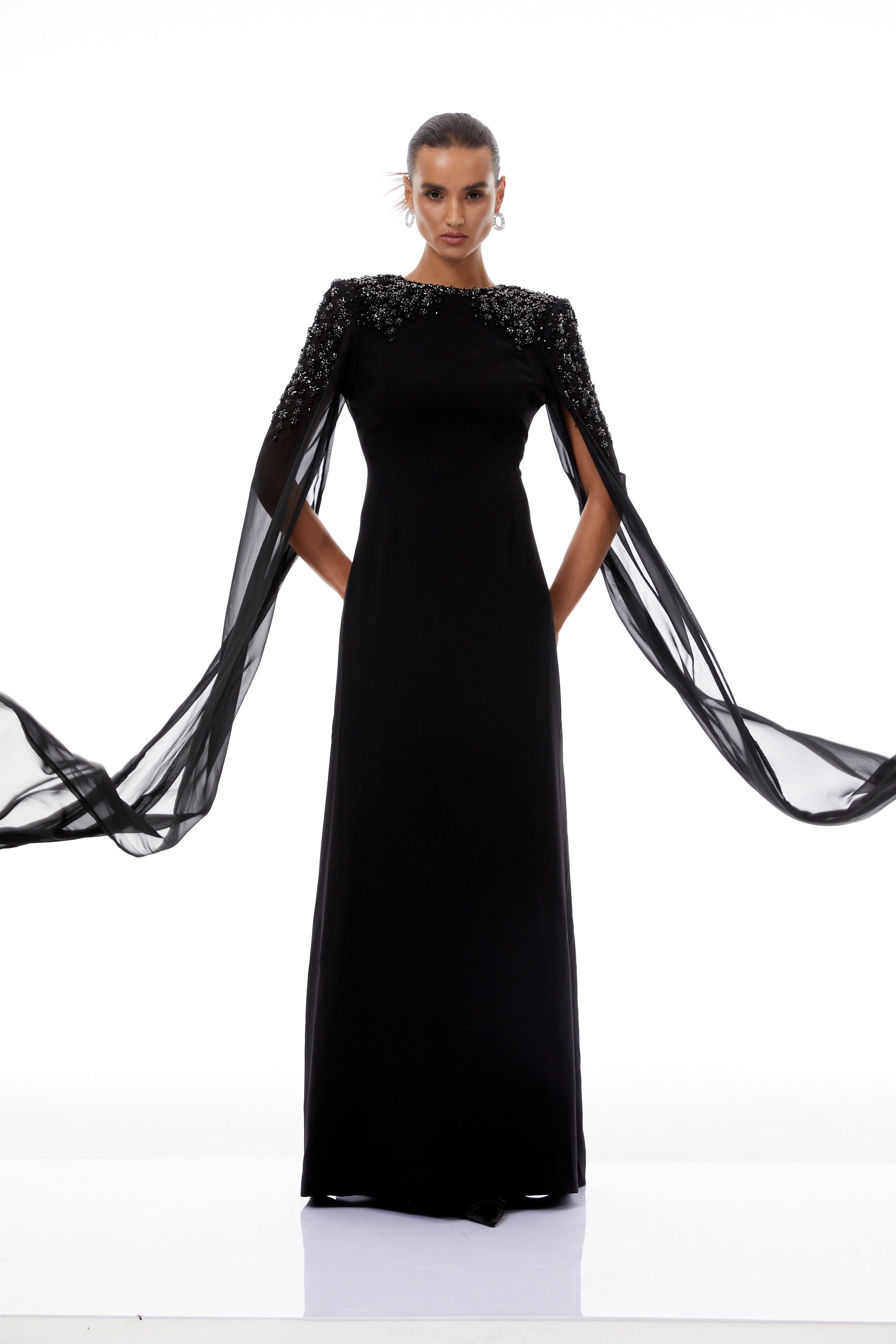 Vestido largo negro Yseult con adornos brillantes y detalles elegantes, diseñado para ocasiones formales y eventos especiales.