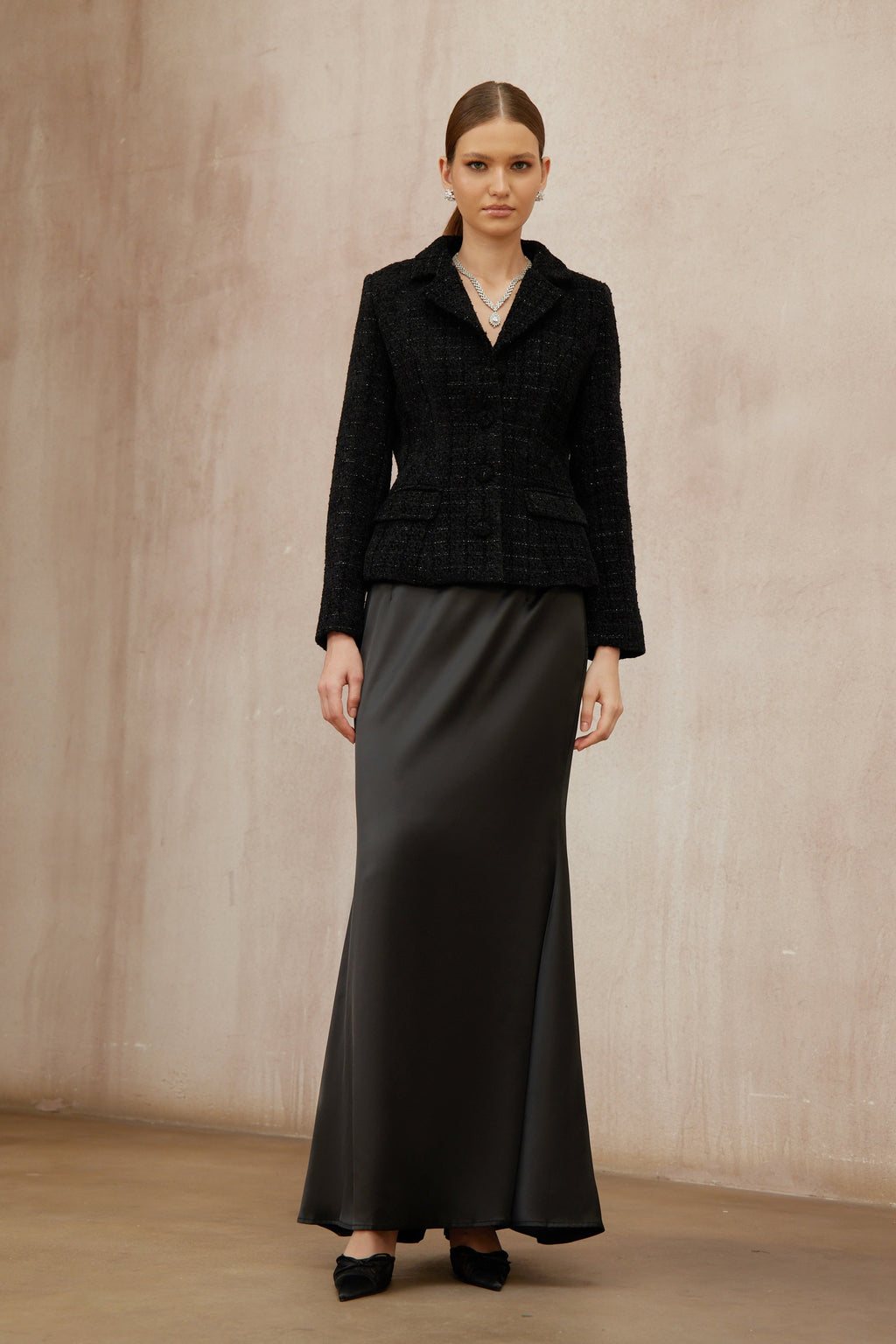 Conjunto de chaqueta de tweed negra y falda de satén de la marca Final Sale, vista en la imagen.