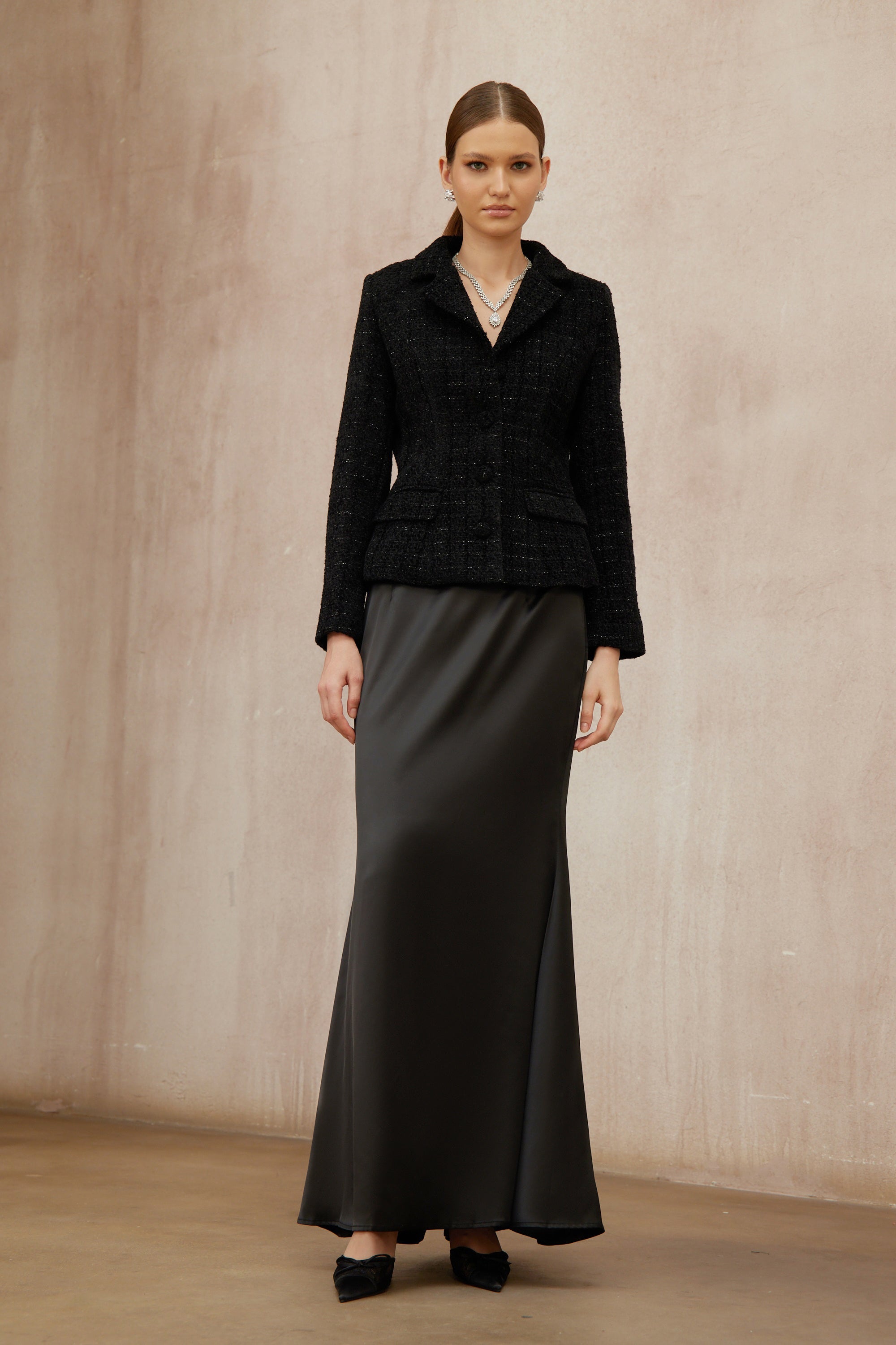 Conjunto de chaqueta de tweed negra y falda de satén de la marca Final Sale, vista en la imagen.