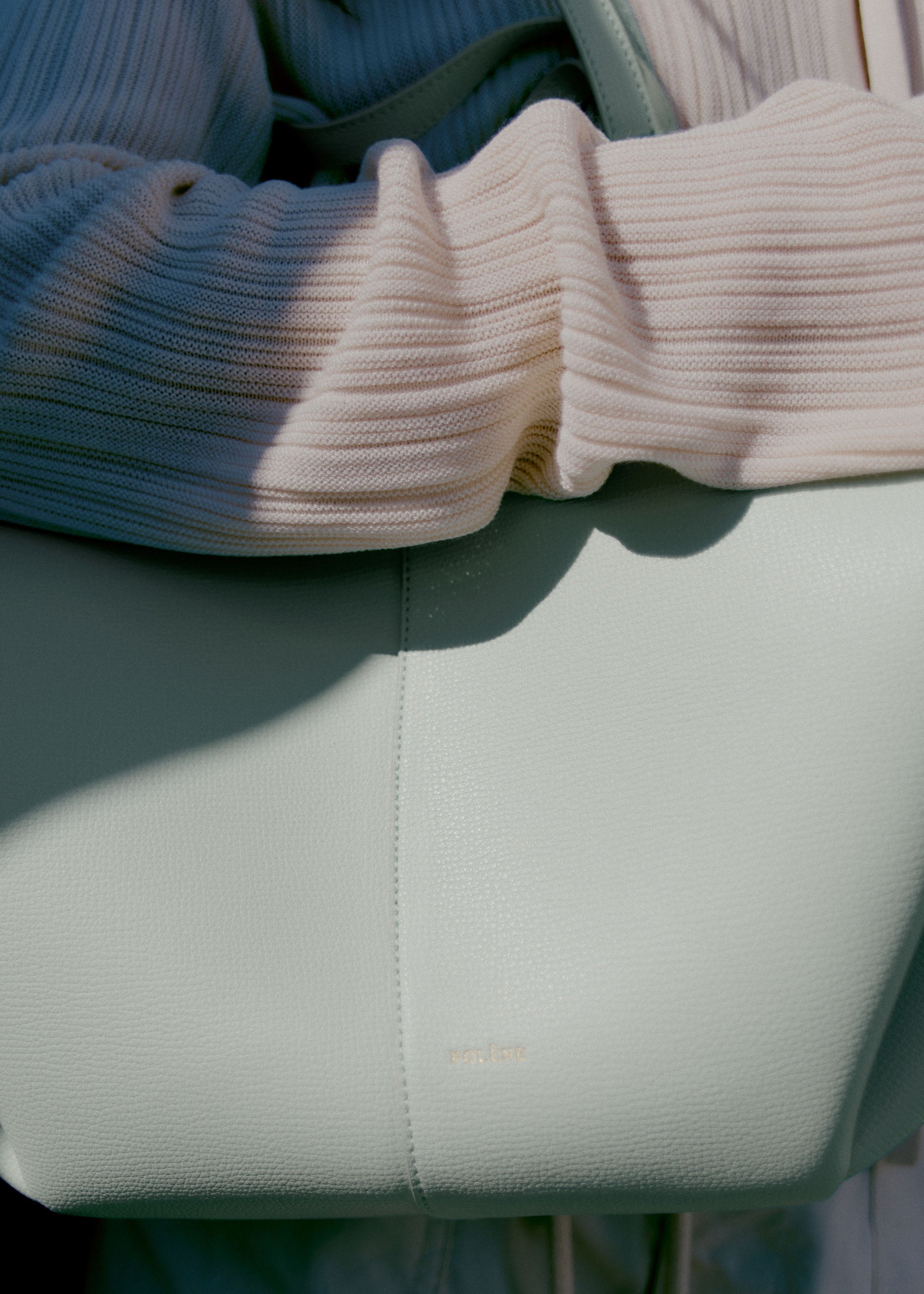 Bolso de mano Polène Cyme en espuma de piel granulada, con diseño elegante y textura texturizada en color neutro.