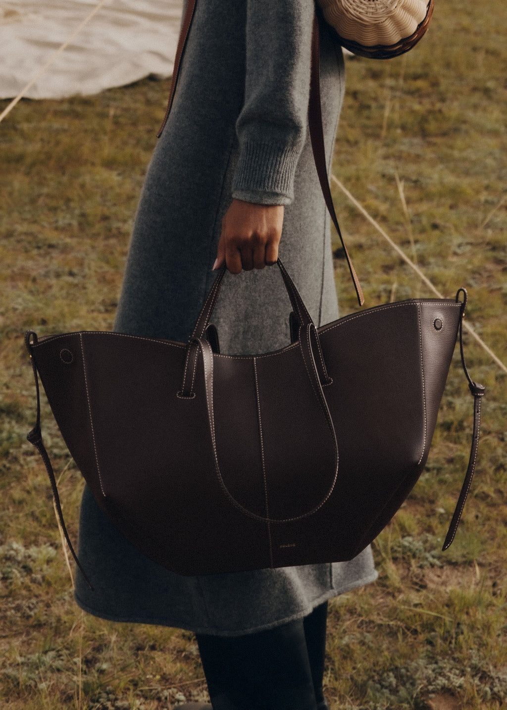 Bolso de mano Polène Cyme en ébano piel granulada con costuras visibles y diseño elegante.