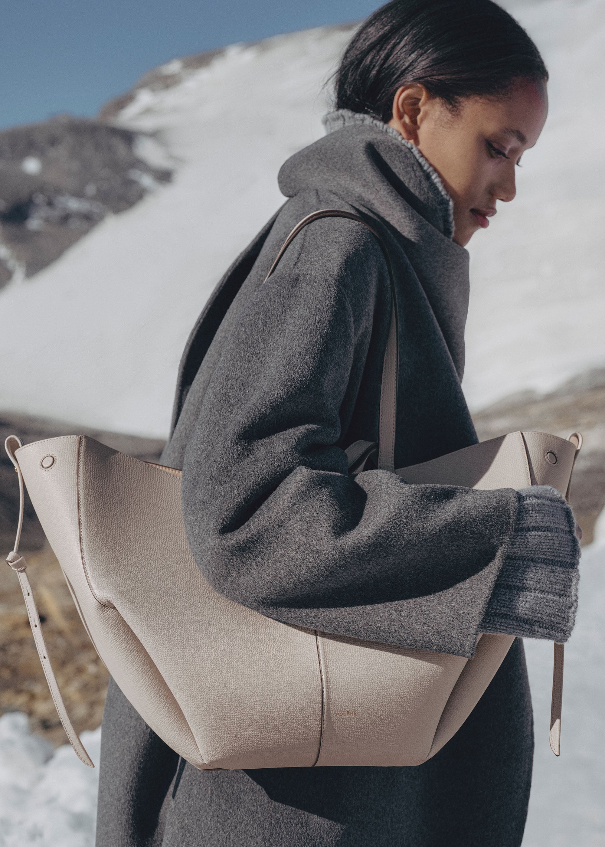 Bolso Polène Cyme con piel granulada en color neutro, detalle de asa y cierre, estilo elegante y moderno.