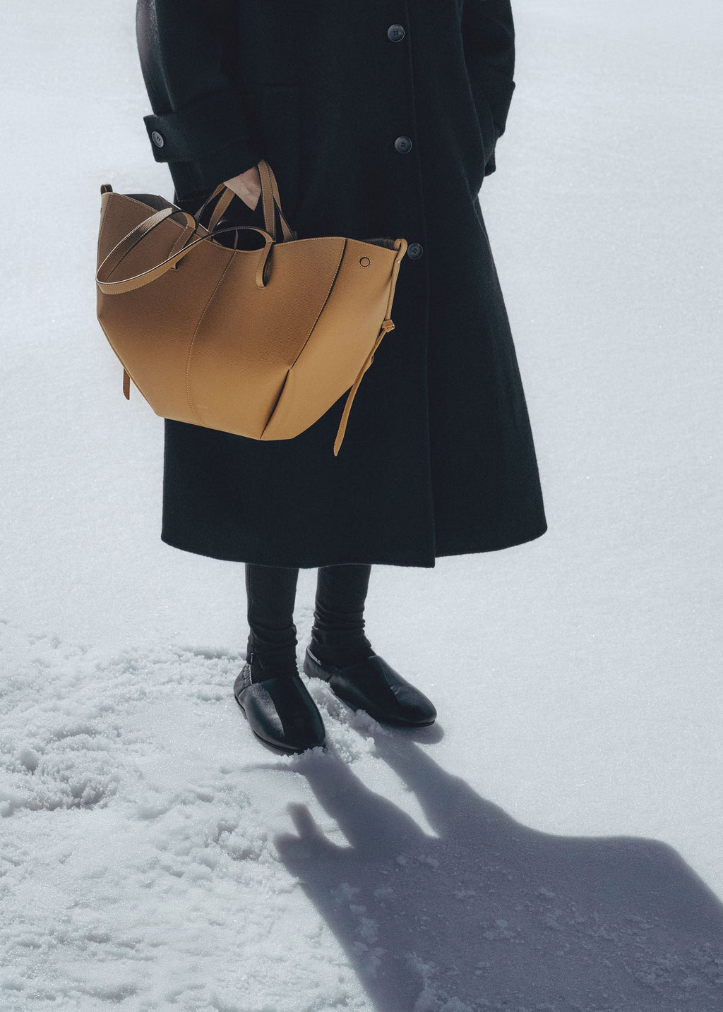 Bolso de mano Polène Cyme en piel ocre granulada, diseño elegante y texturizado, con asa y detalles de alta calidad.
