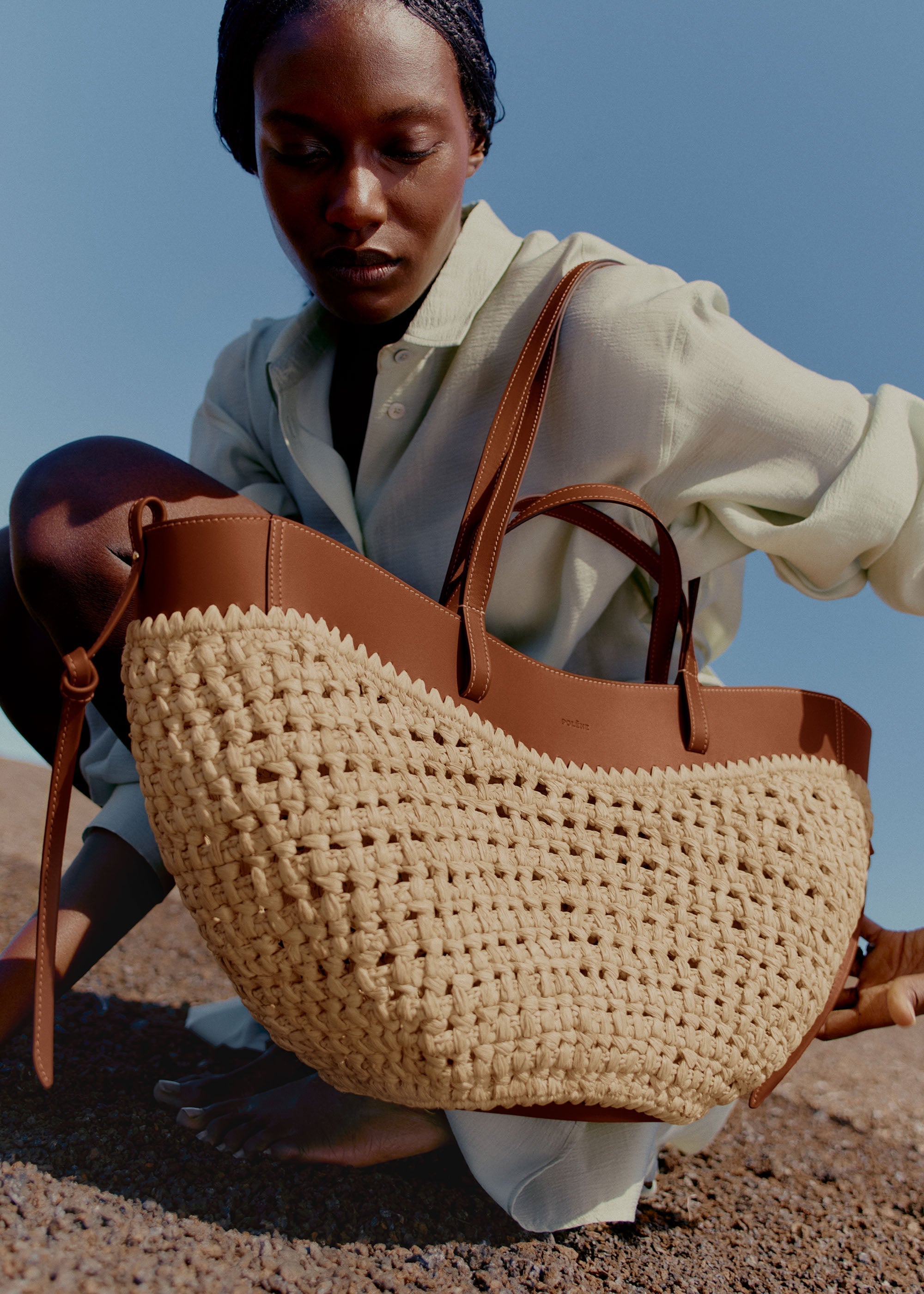 Bolso de mano Polène Cyme en rafia, con asas cortas y diseño elegante.