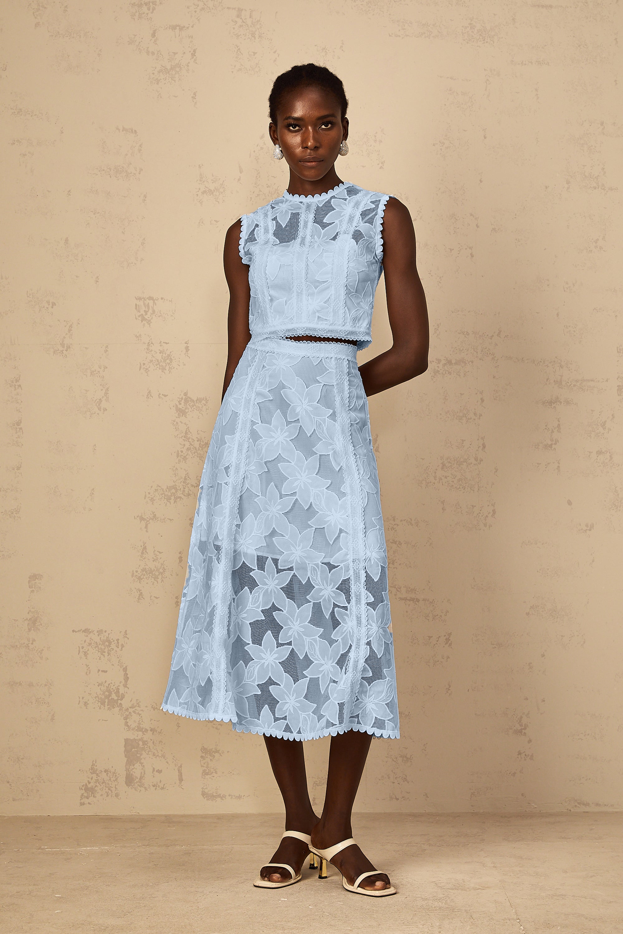 Conjunto de top y falda azul con bordados florales de MRMelbourne, estilo elegante y femenino, visible en la imagen.