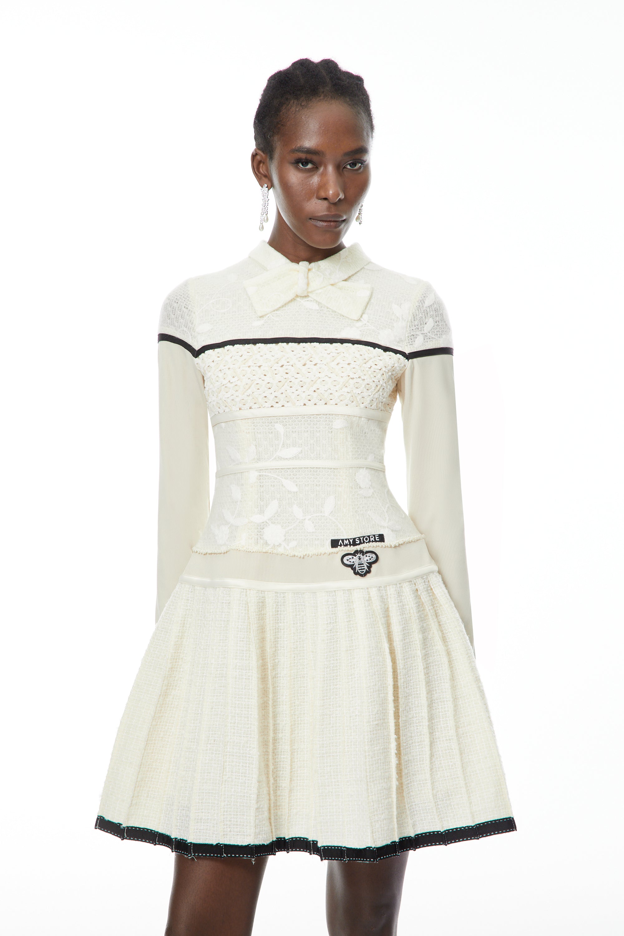 Vestido mini plisado blanco Bridget de MRNewyork con lazo, elegante y femenino, perfecto para ocasiones semiformales.