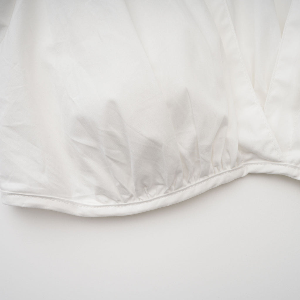 Conjunto de blusa y falda blanca con frunces de la marca Bridal, mostrando detalles elegantes y estilo sofisticado en la imagen.