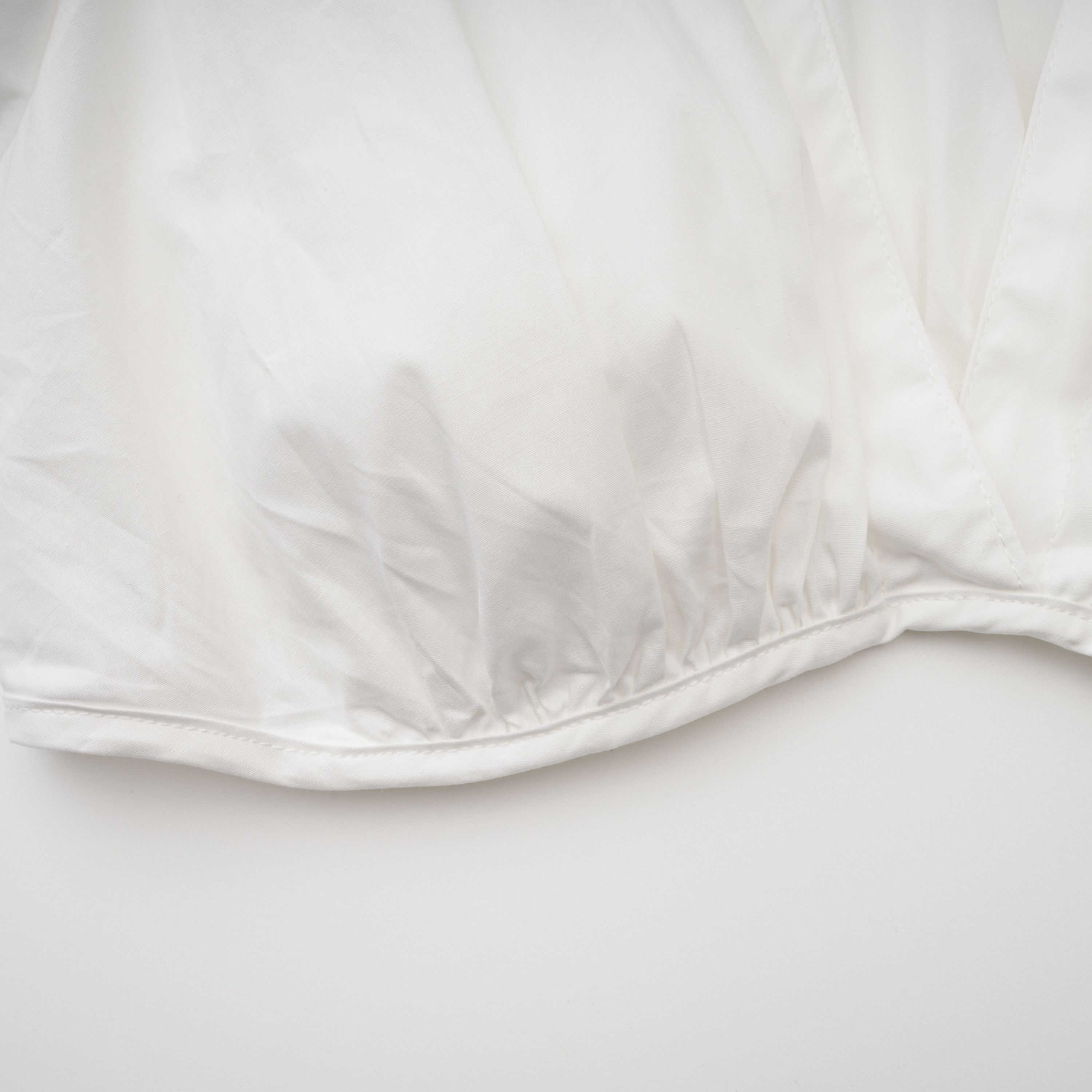 Conjunto de blusa y falda blanca con frunces de la marca Bridal, mostrando detalles elegantes y estilo sofisticado en la imagen.