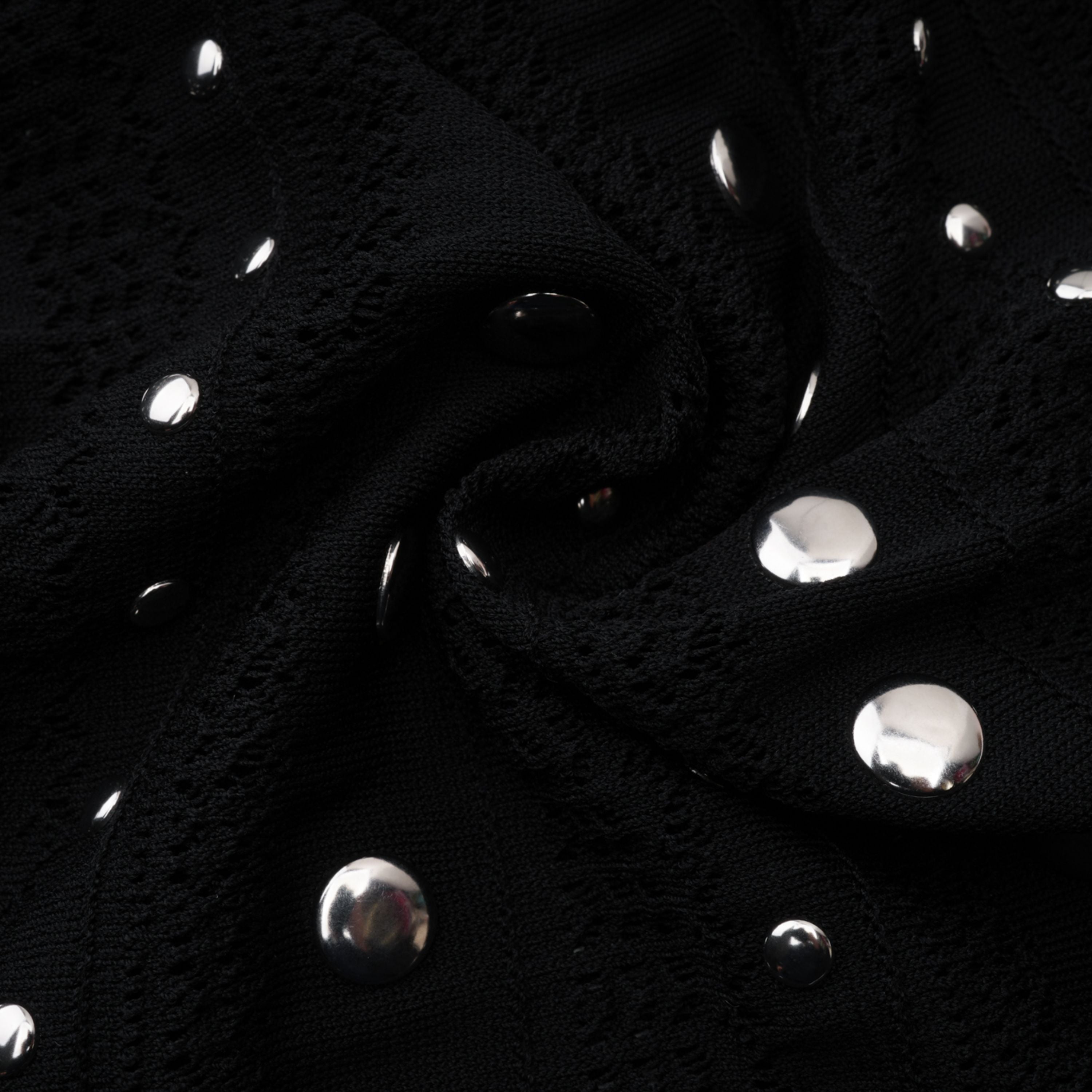 Vestido midi de encaje y punto con manga larga y tachuelas negras de Bridal, diseñado por Chloé, visible en la imagen.
